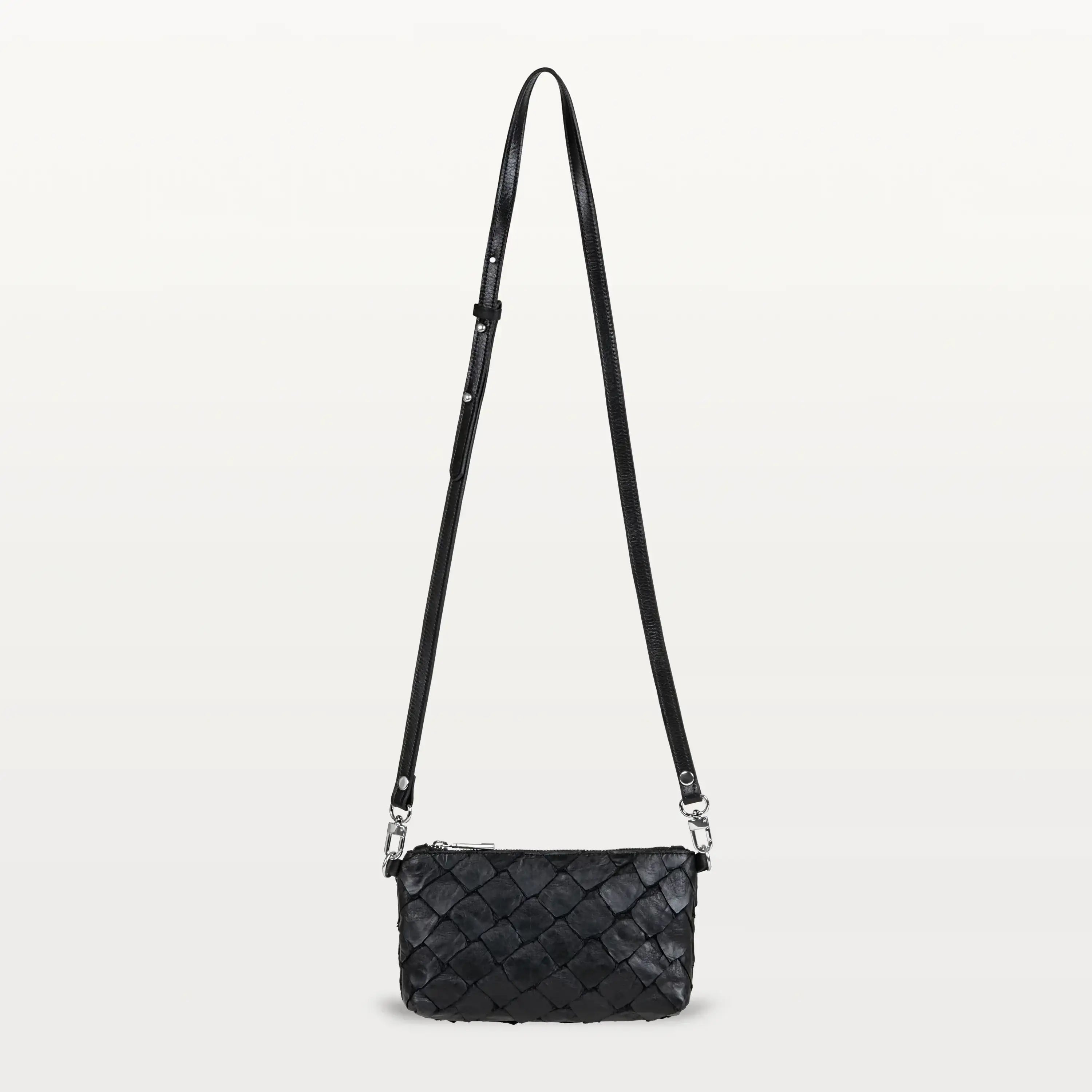 Small black crossbody bag made of textured Pirarucu fish leather with silver hardware.