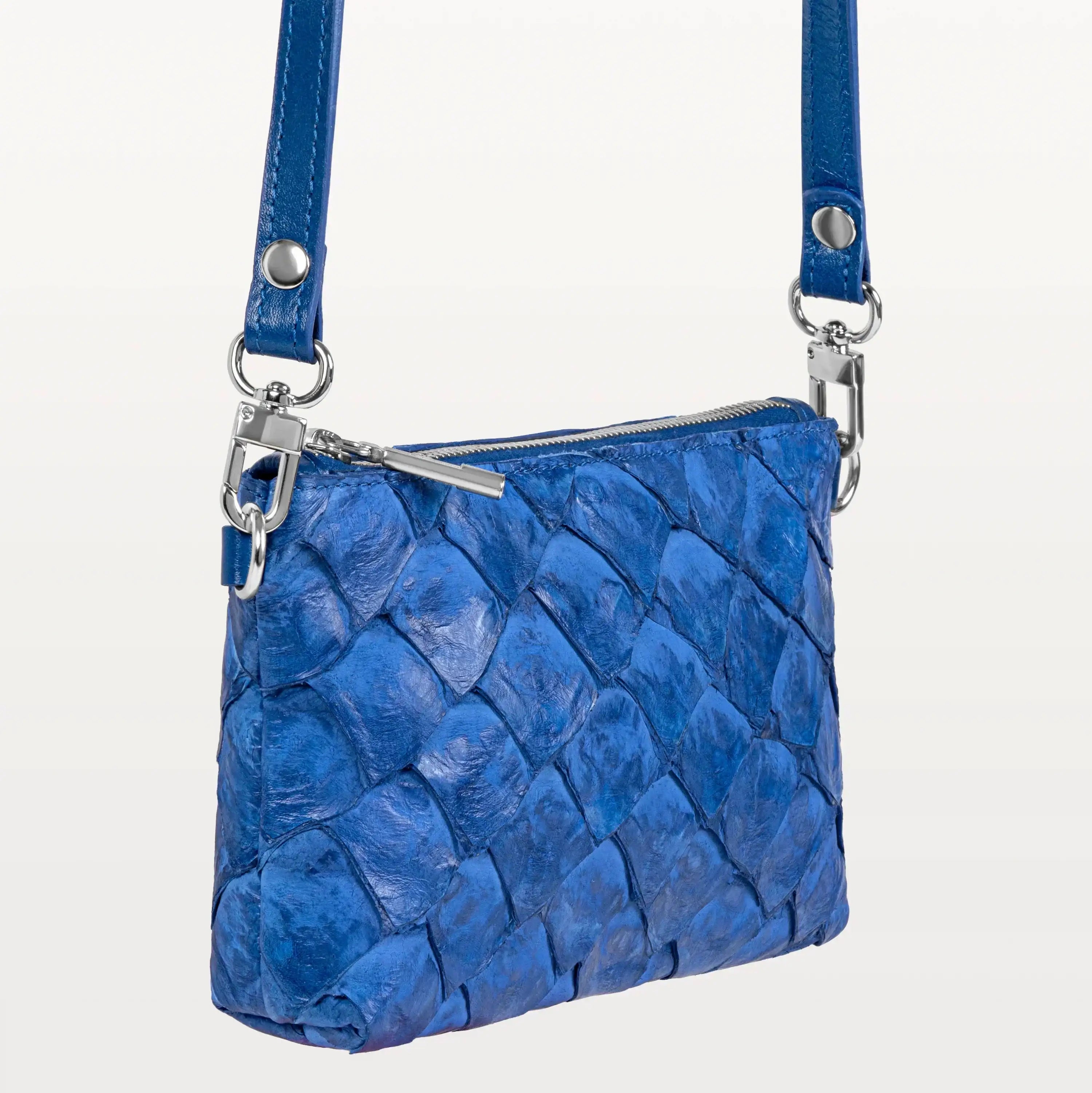 Small rectangular cobalt blue crossbody bag handcrafted from sustainable pirarucu fish leather with silver hardware.