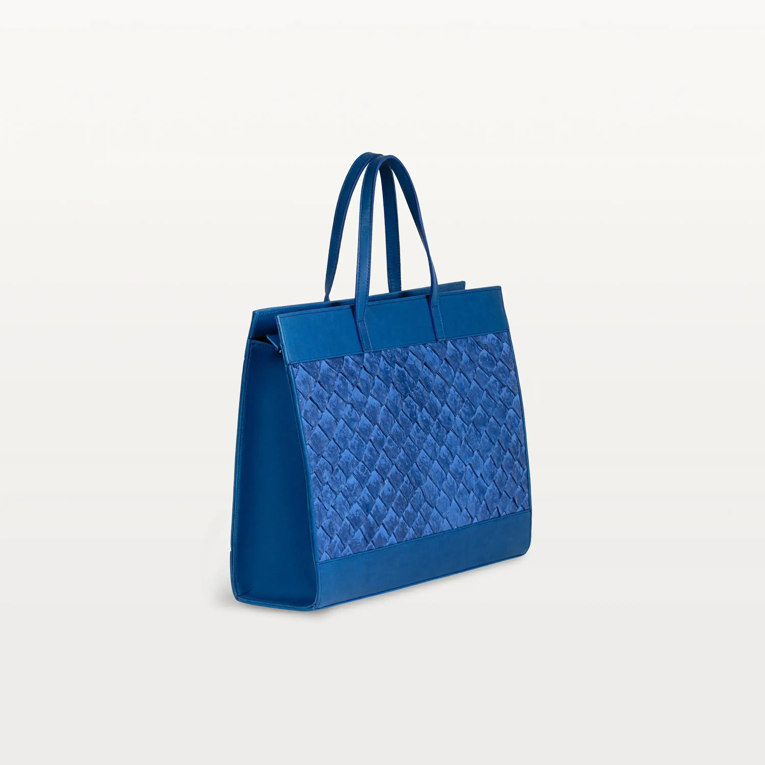 Gusseted side of the Braemar tote bag in cobalt blue pirarucu leather with the top handles up.
