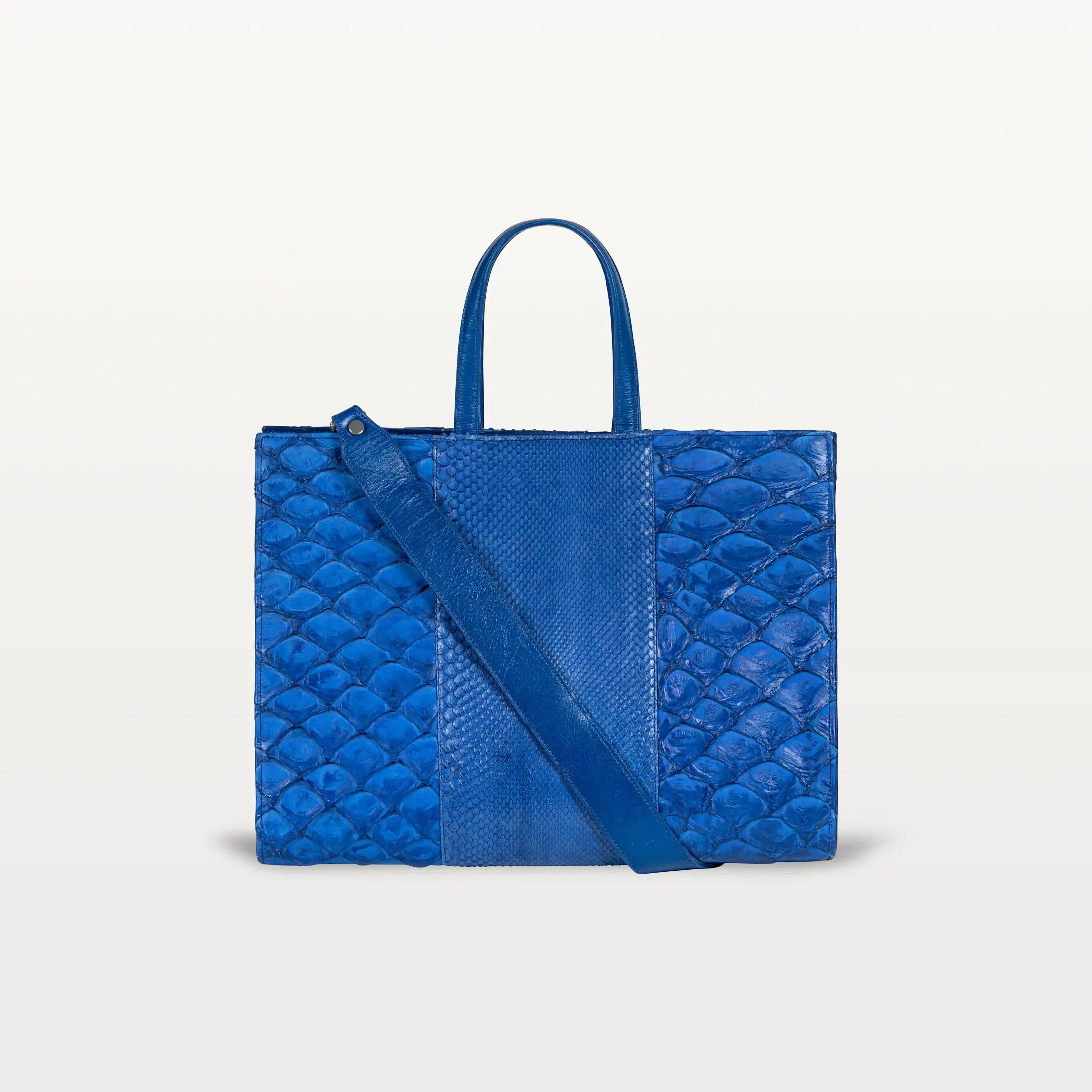 The Braemar tote bag in cobalt blue python and pirarucu leather. A large, structured bag with top handles and crossbody strap.