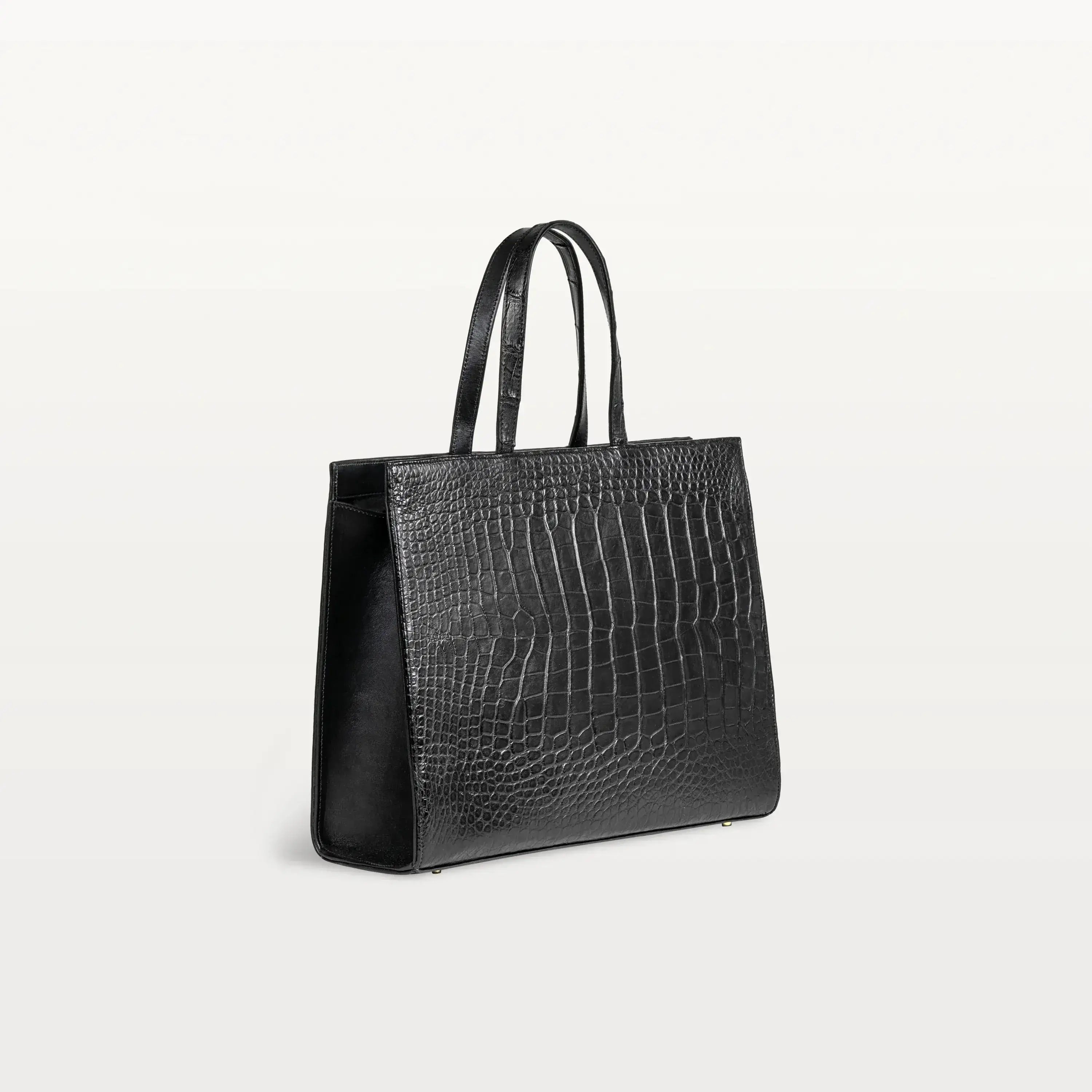 Gusseted side of the Braemar tote bag in black alligator leather with the top handles up.