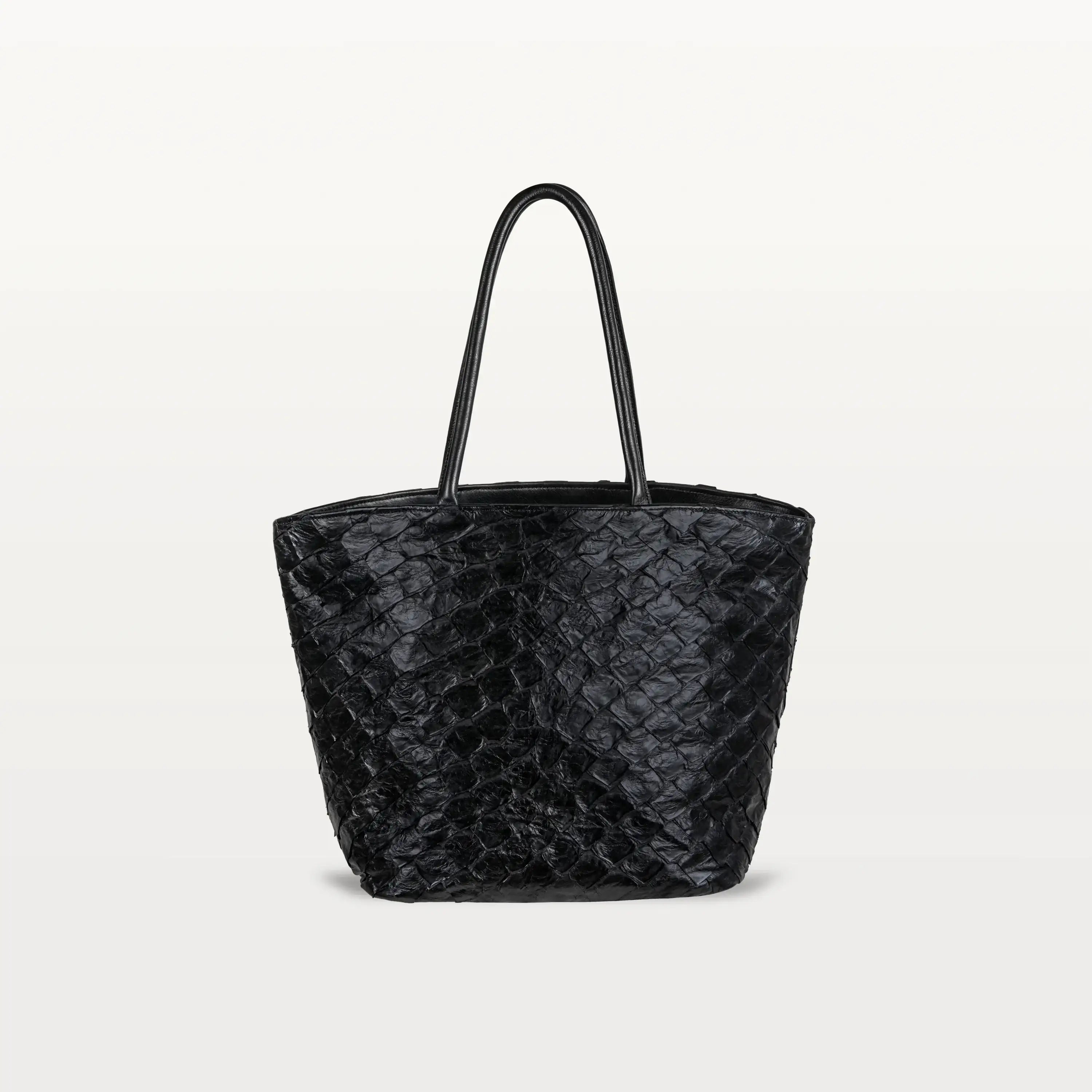 The Delray Shopper in black pirarucu leather, a large tote bag with a unique fish scale texture and two top handles.