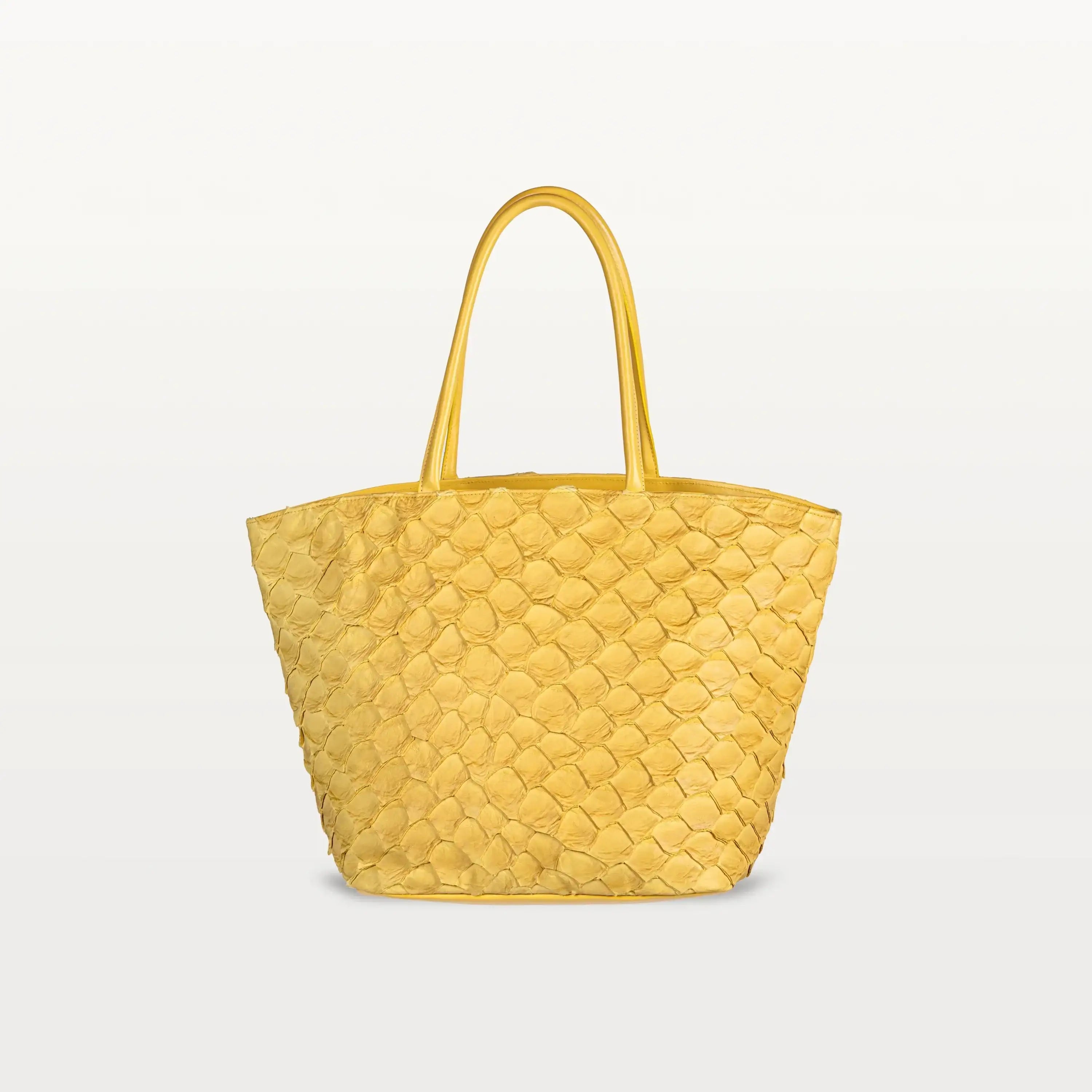 The Delray Shopper in honey yellow pirarucu leather, a large tote bag with a unique fish scale texture and two top handles.