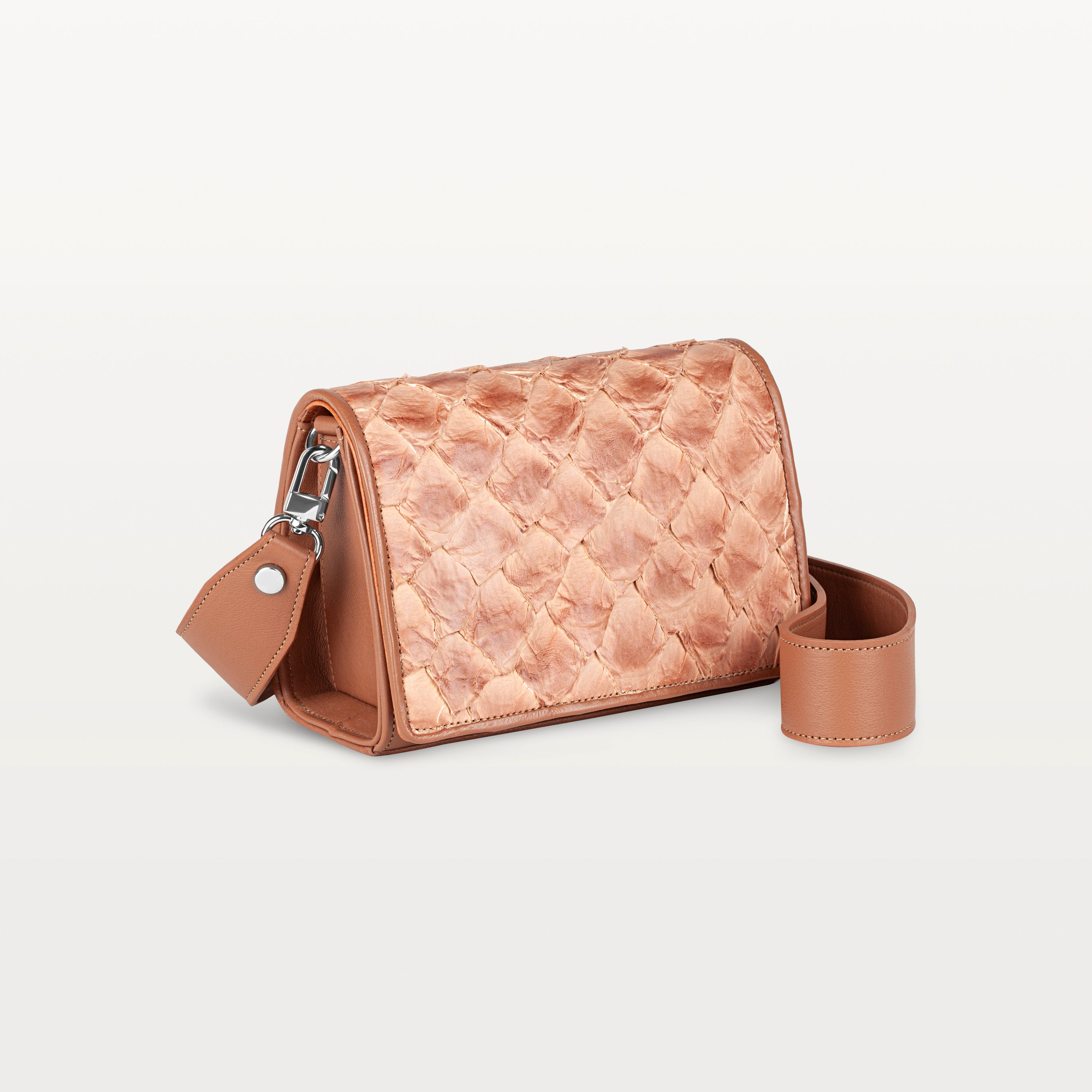 Side view of the rectangular cognac Lola crossbody bag in scale-like pirarucu fish leather with thick detachable strap and silver hardware
