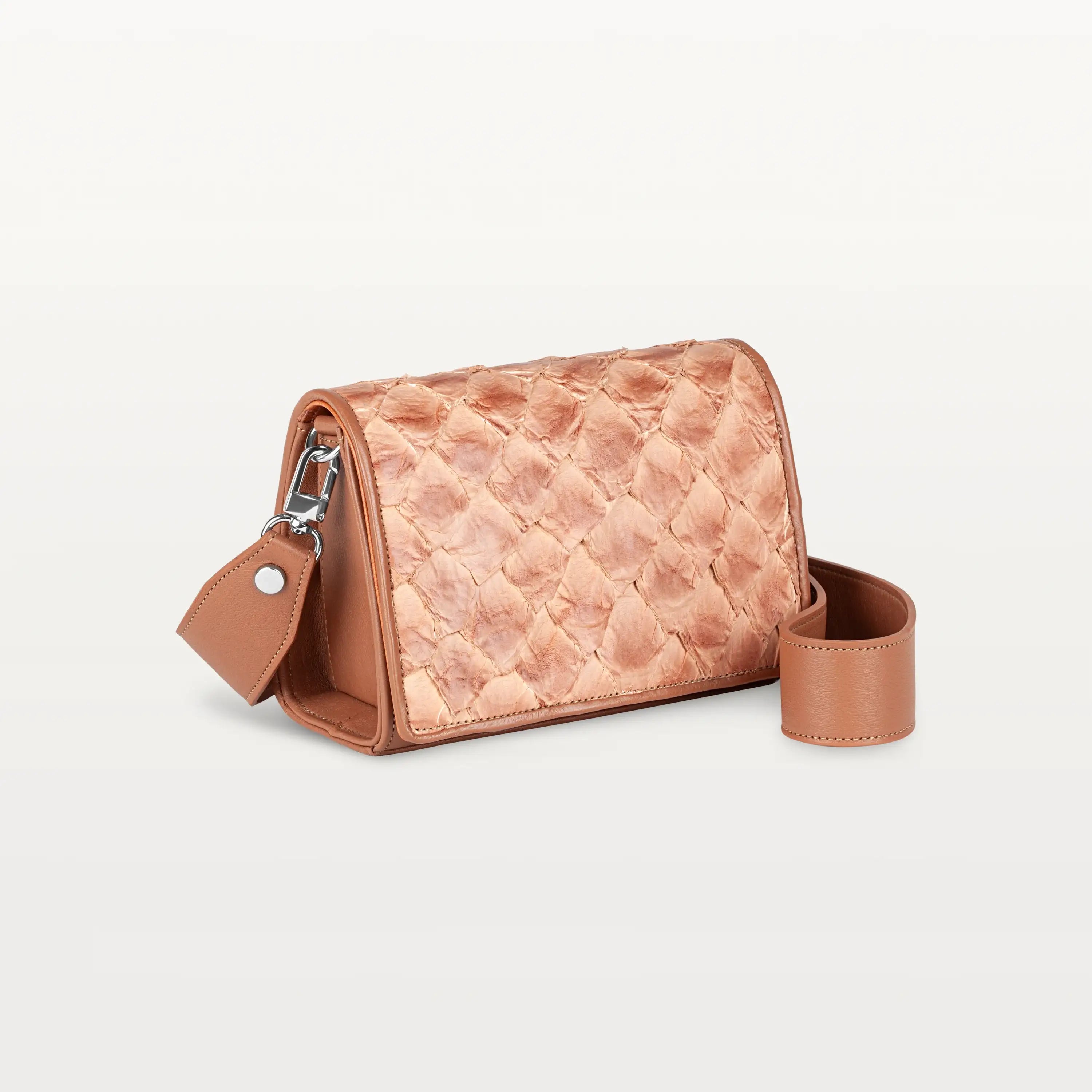 Side view of the rectangular cognac Lola crossbody bag in scale-like pirarucu fish leather with thick detachable strap and silver hardware