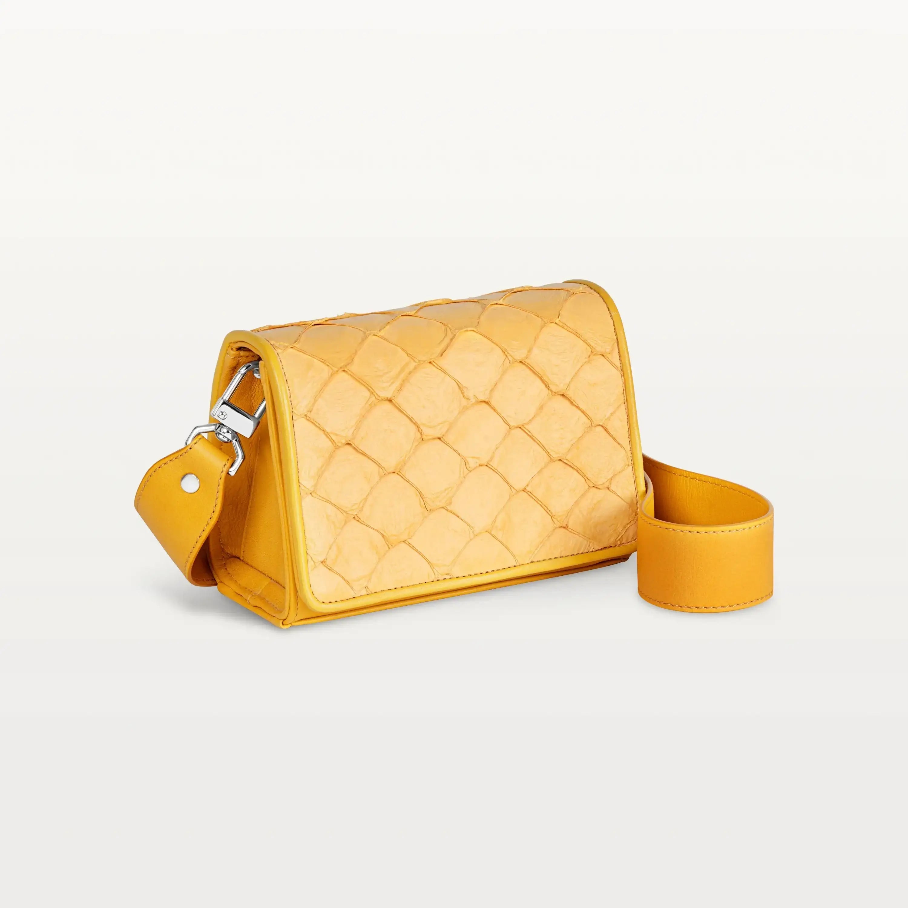 Side view of the rectangular honey yellow Lola crossbody bag in scale-like pirarucu fish leather with thick detachable strap and silver hardware