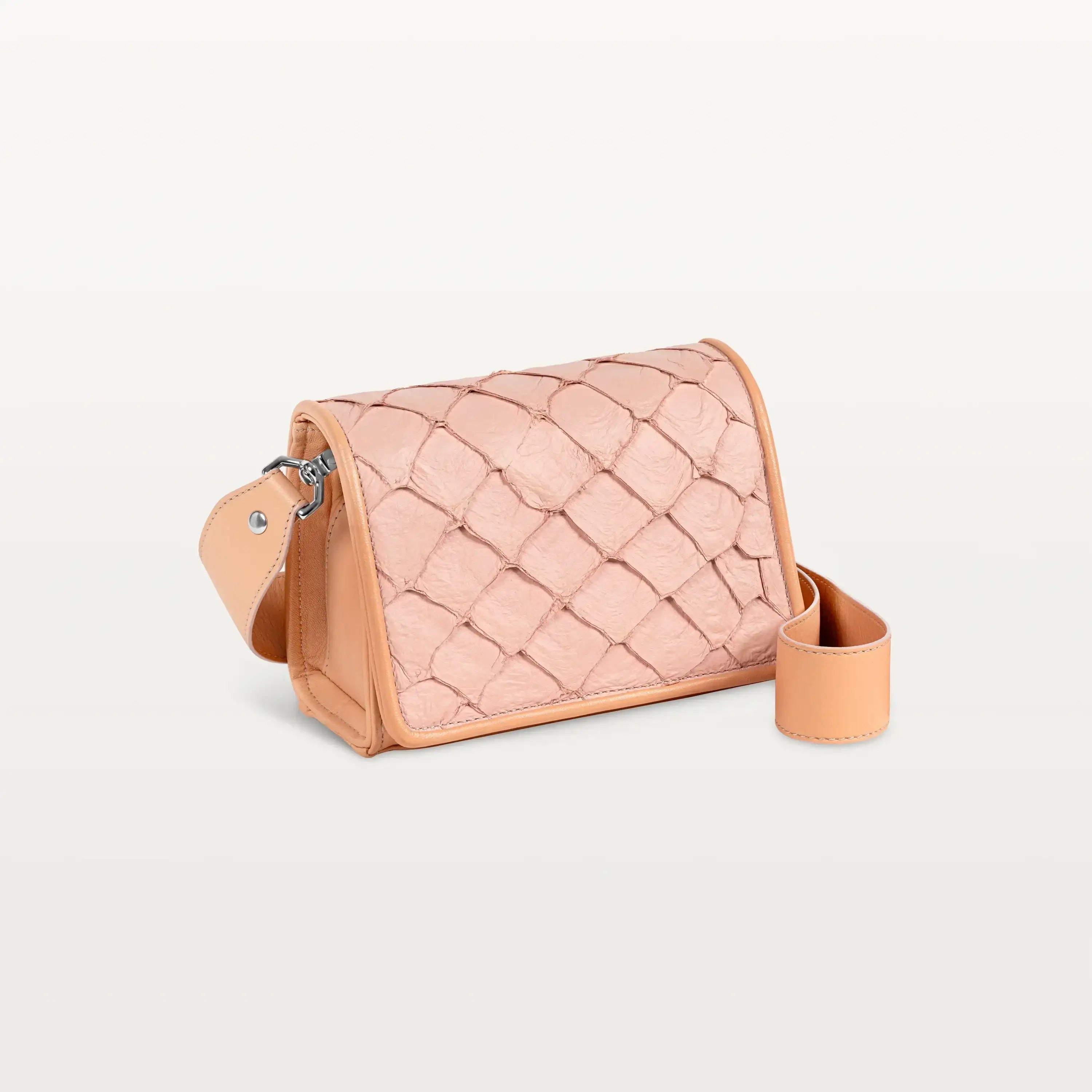 Side view of the rectangular pink Lola crossbody bag in scale-like pirarucu fish leather with thick detachable strap and silver hardware
