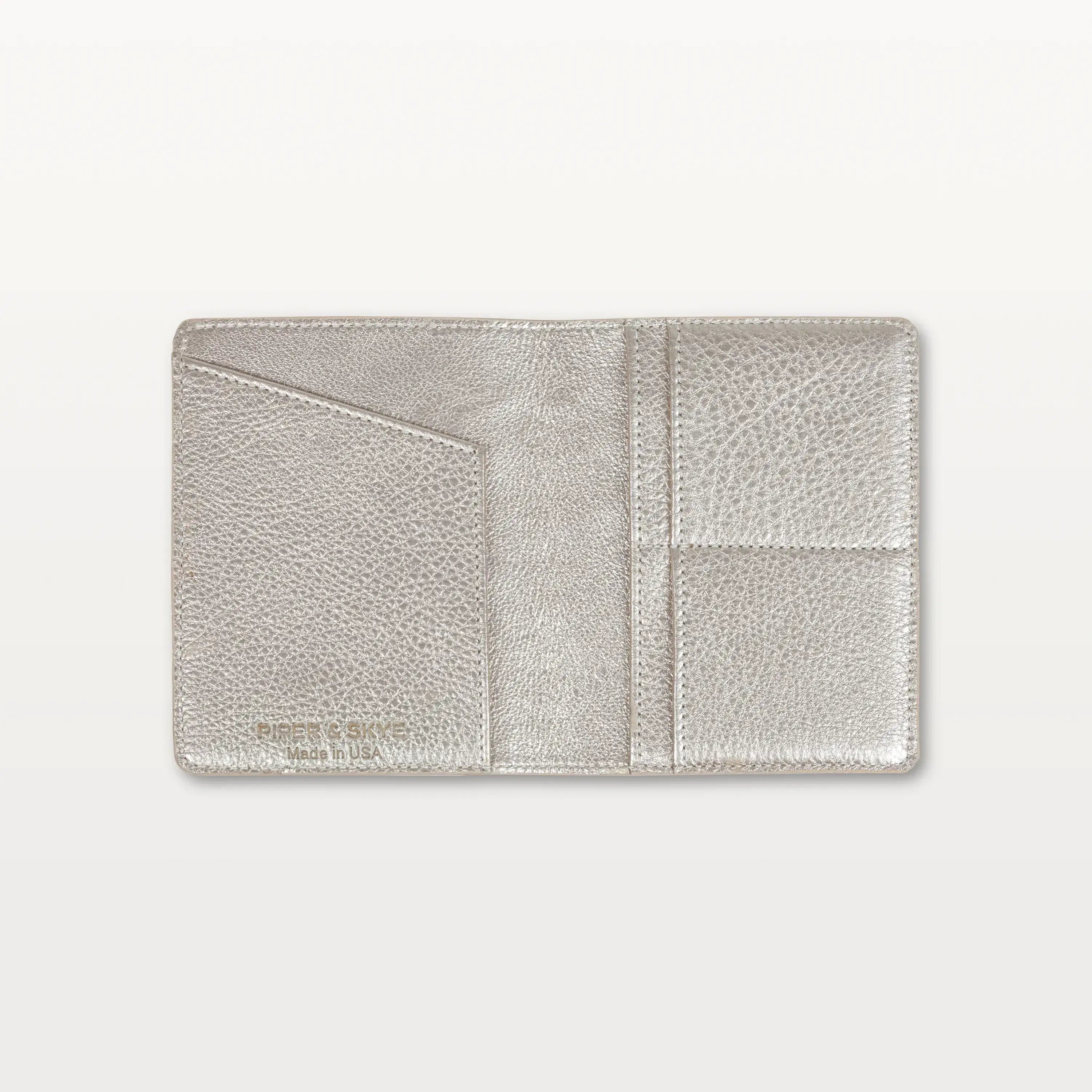 Open view of the metallic gold alligator leather passport holder showing the leather interior and slip pockets.