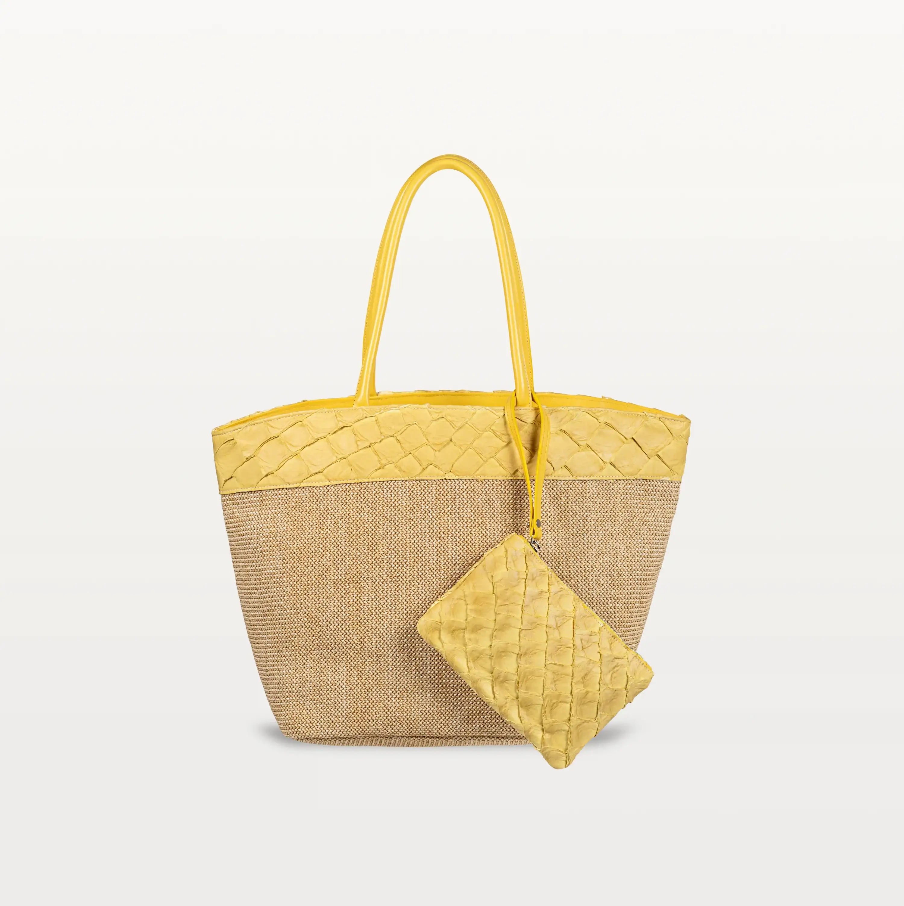 The Rio Beach Bag with a camel raffia body and honey yellow pirarucu leather trim. A matching honey yellow pirarucu leather wristlet hangs from the strap