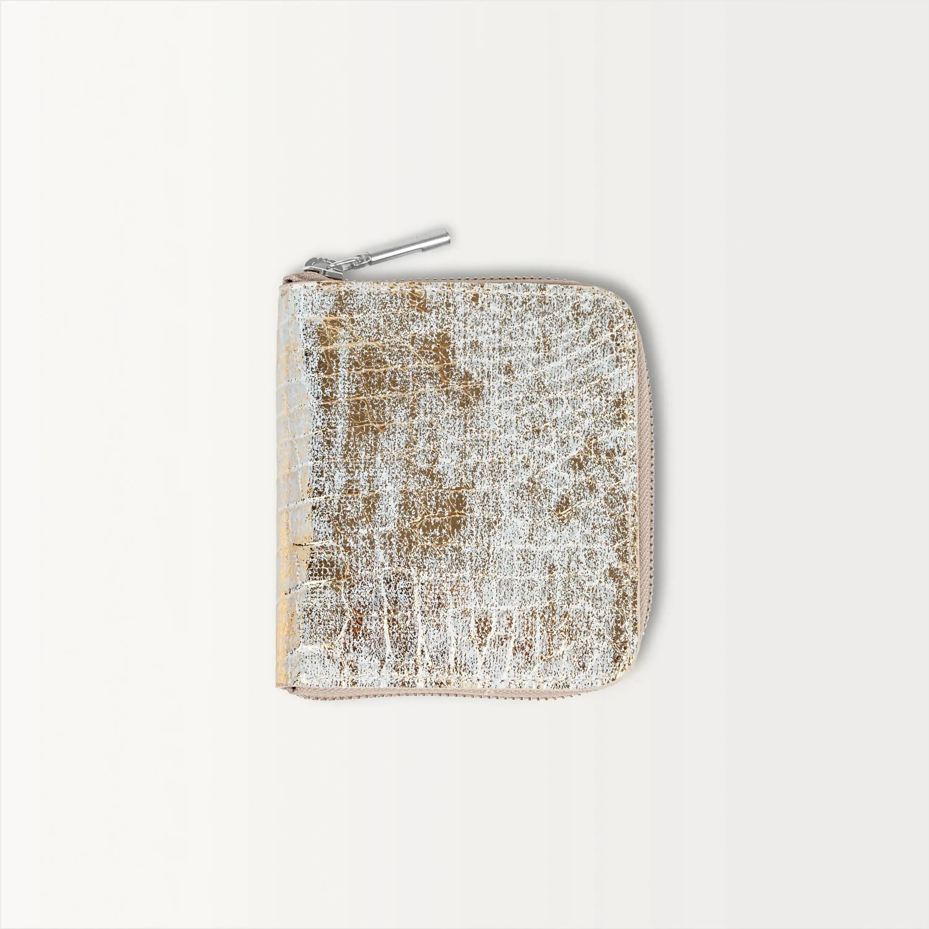 The Shore Zip Wallet in metallic gold alligator leather, shown closed with a silver zipper pull