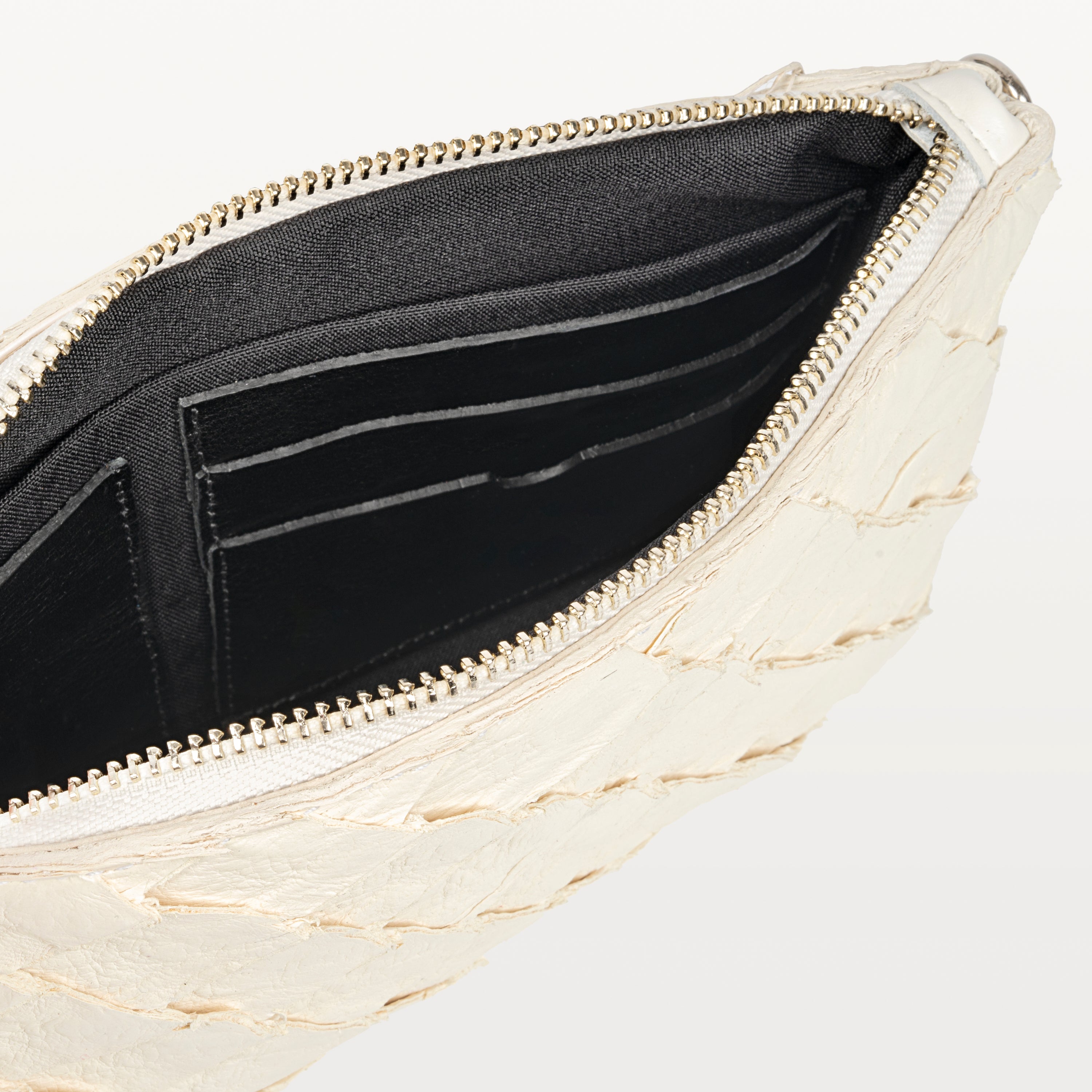 Interior of the sustainable white pirarucu fish leather crossbody bag showing card slots and the silver top zipper. 