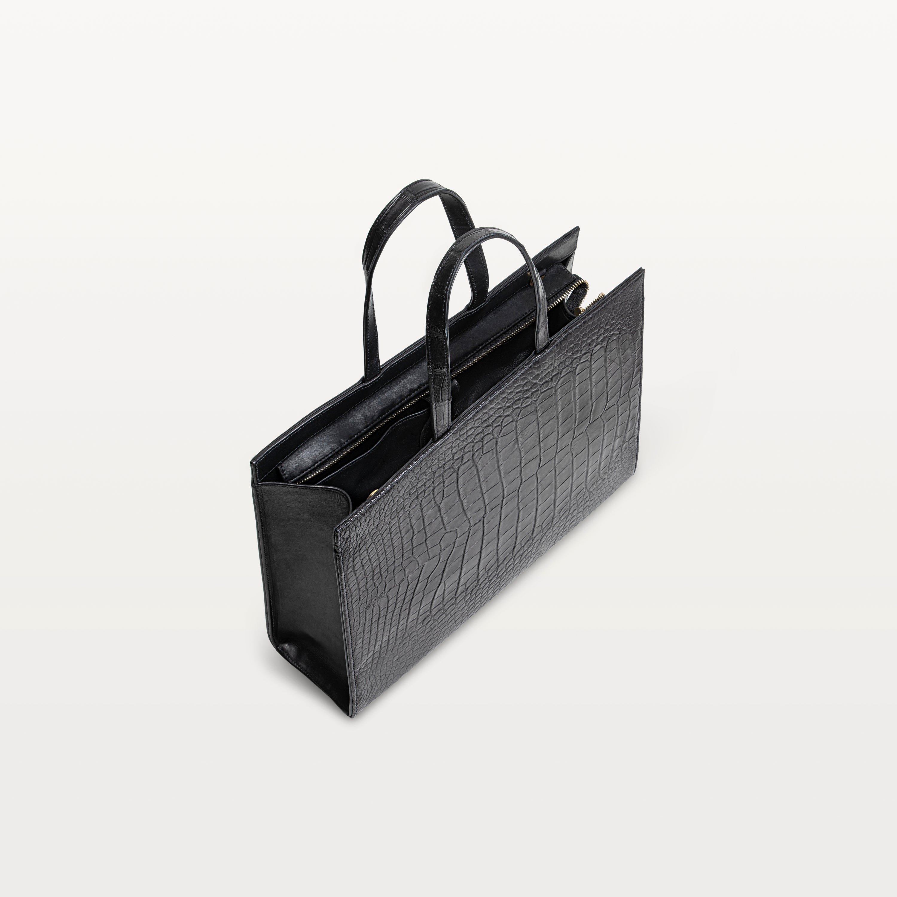 Braemar tote bag in black alligator leather with the top zipper open showing the black interior. 