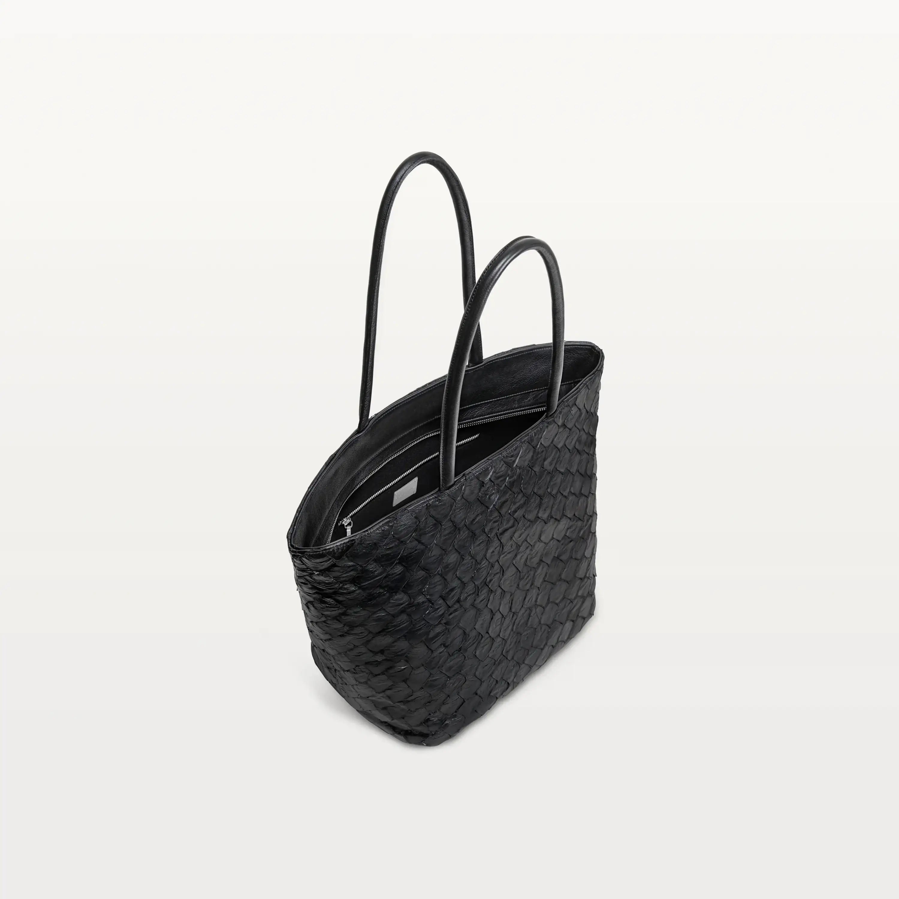 Top zipper of the Delray shopper in black pirarucu leather open to show the black interior lining and inner zipper pocket.