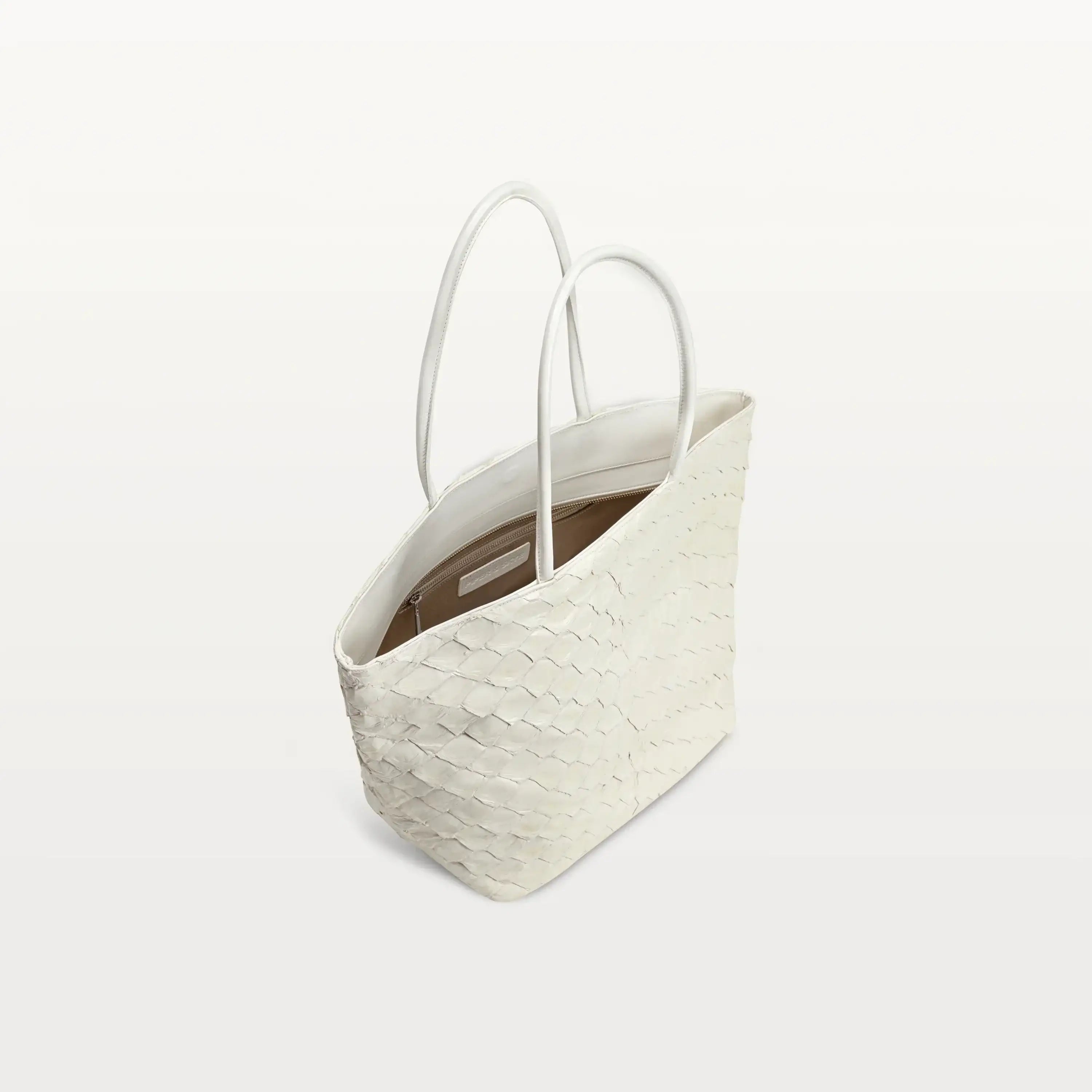 Top zipper of the Delray shopper in clay white pirarucu leather open to show the beige interior lining and inner zipper pocket.