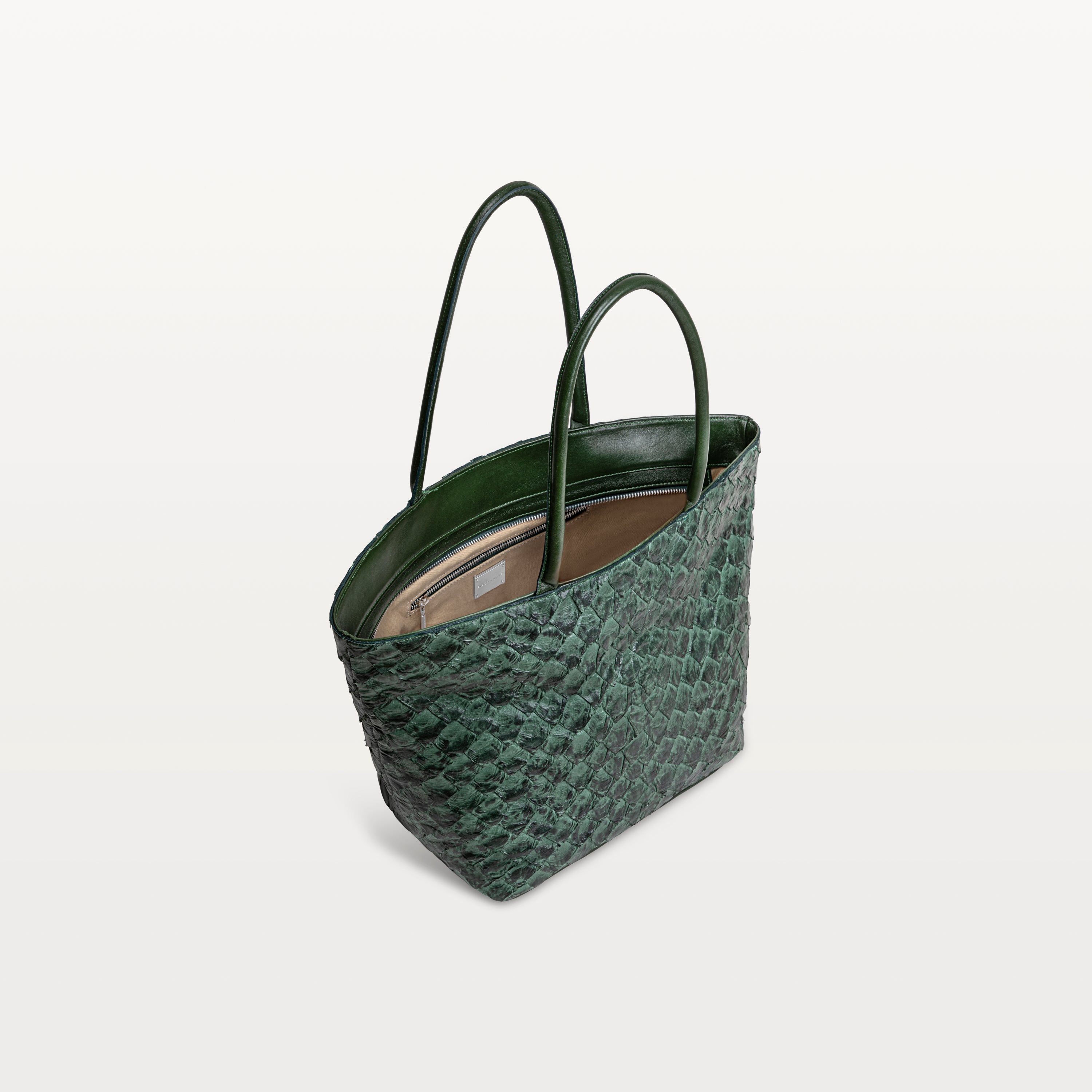 Top zipper of the Delray shopper in verdant green pirarucu leather open to show the beige interior lining and inner zipper pocket.