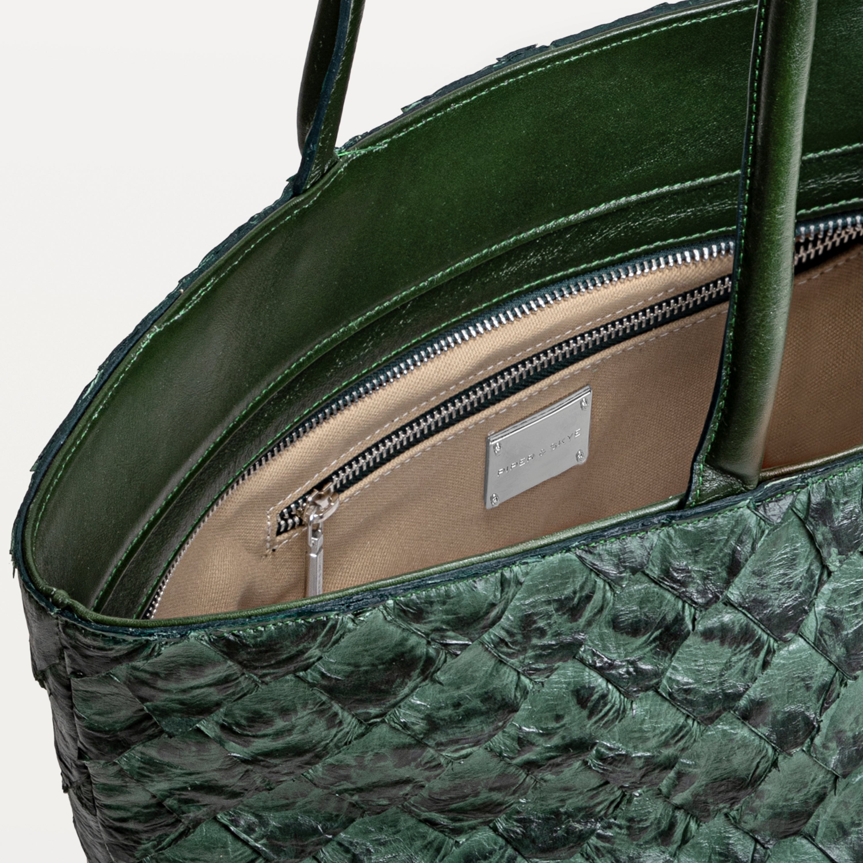 Delray shopper tote bag in verdant green pirarucu leather opened to show the beige interior lining and inner zipper pocket. 