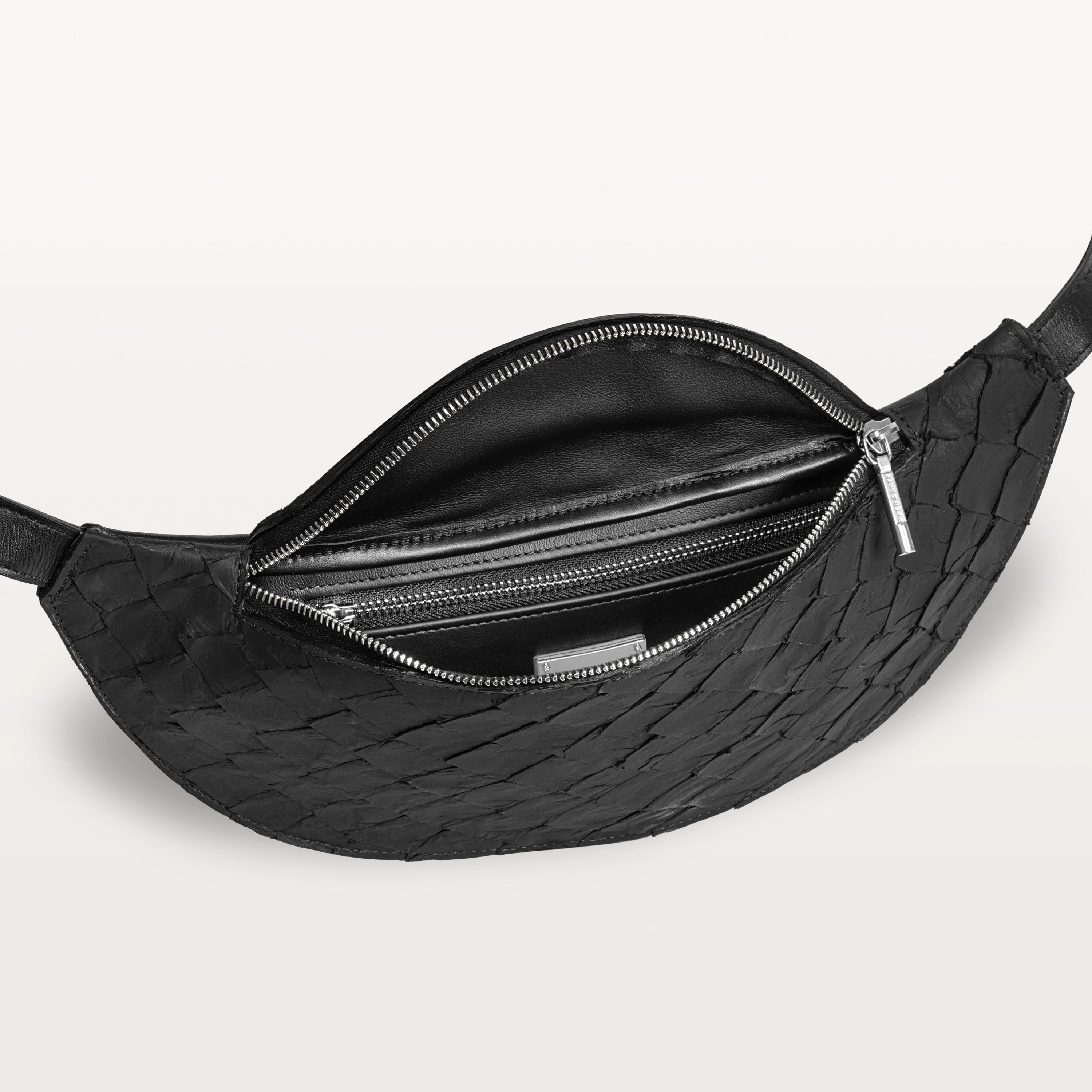 Mac Pack belt bag in black pirarucu fish leather with the top zipper open revealing an inner zippered pocket