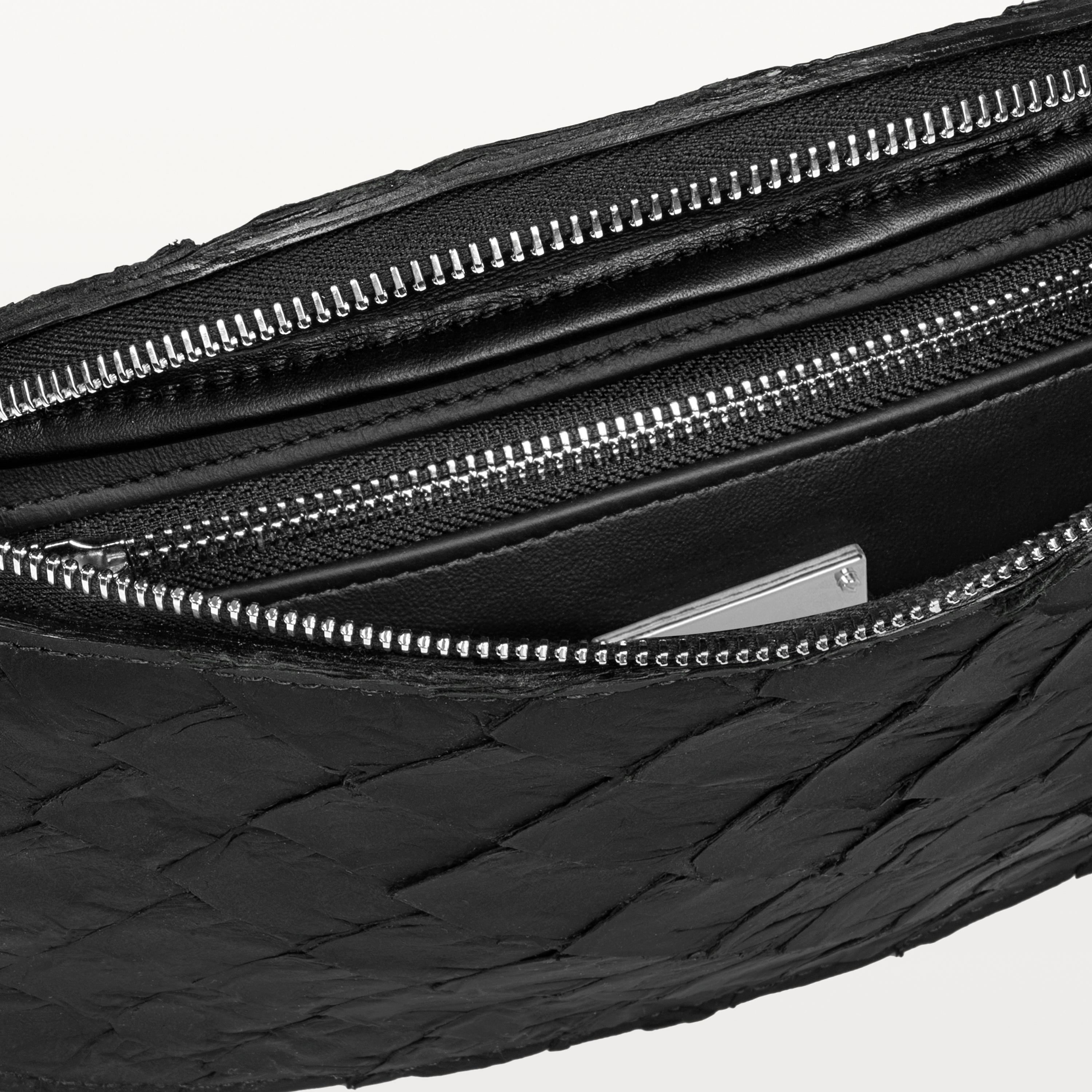 Black interior of the black pirarucu Mac Pack belt bag showing the inner zippered pocket. 