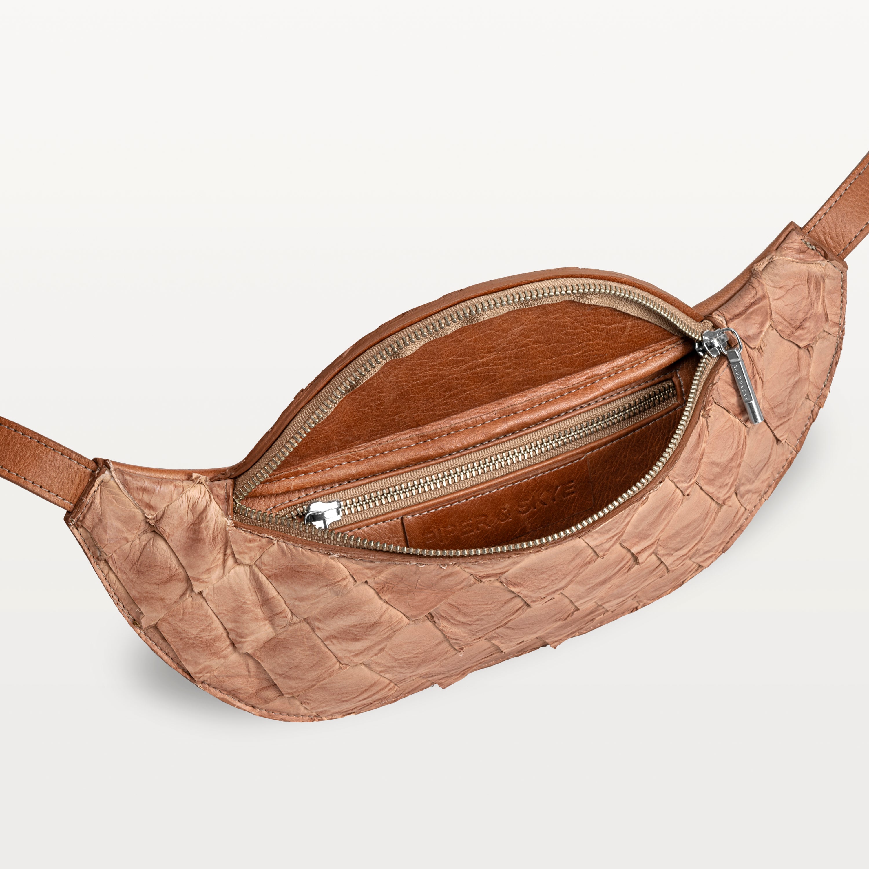 Mac Pack belt bag in cognac pirarucu fish leather with the top zipper open revealing an inner zippered pocket