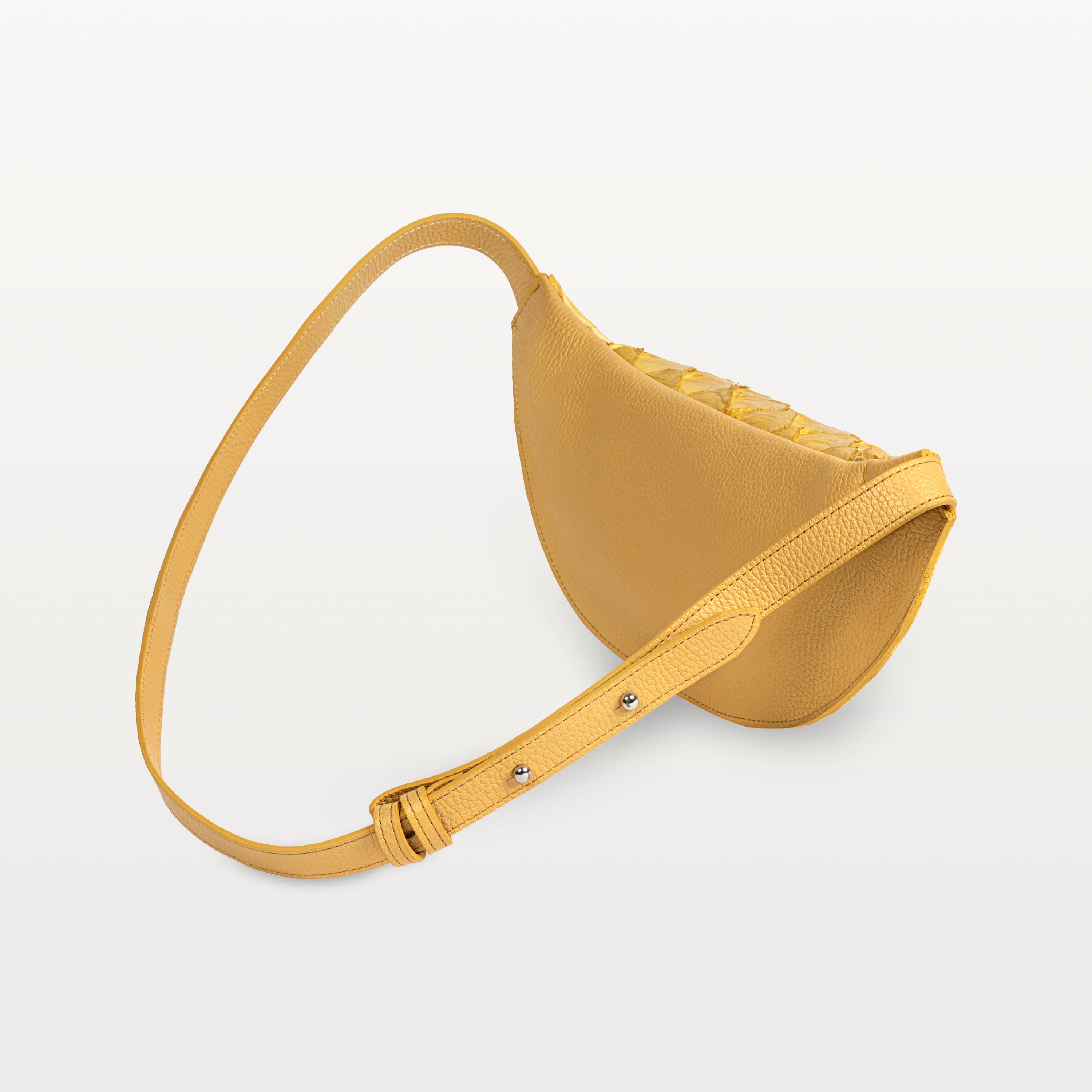 Back of the honey yellow pirarucu Mac Pack showing the bovine leather backside of the body and adjustable leather strap. 