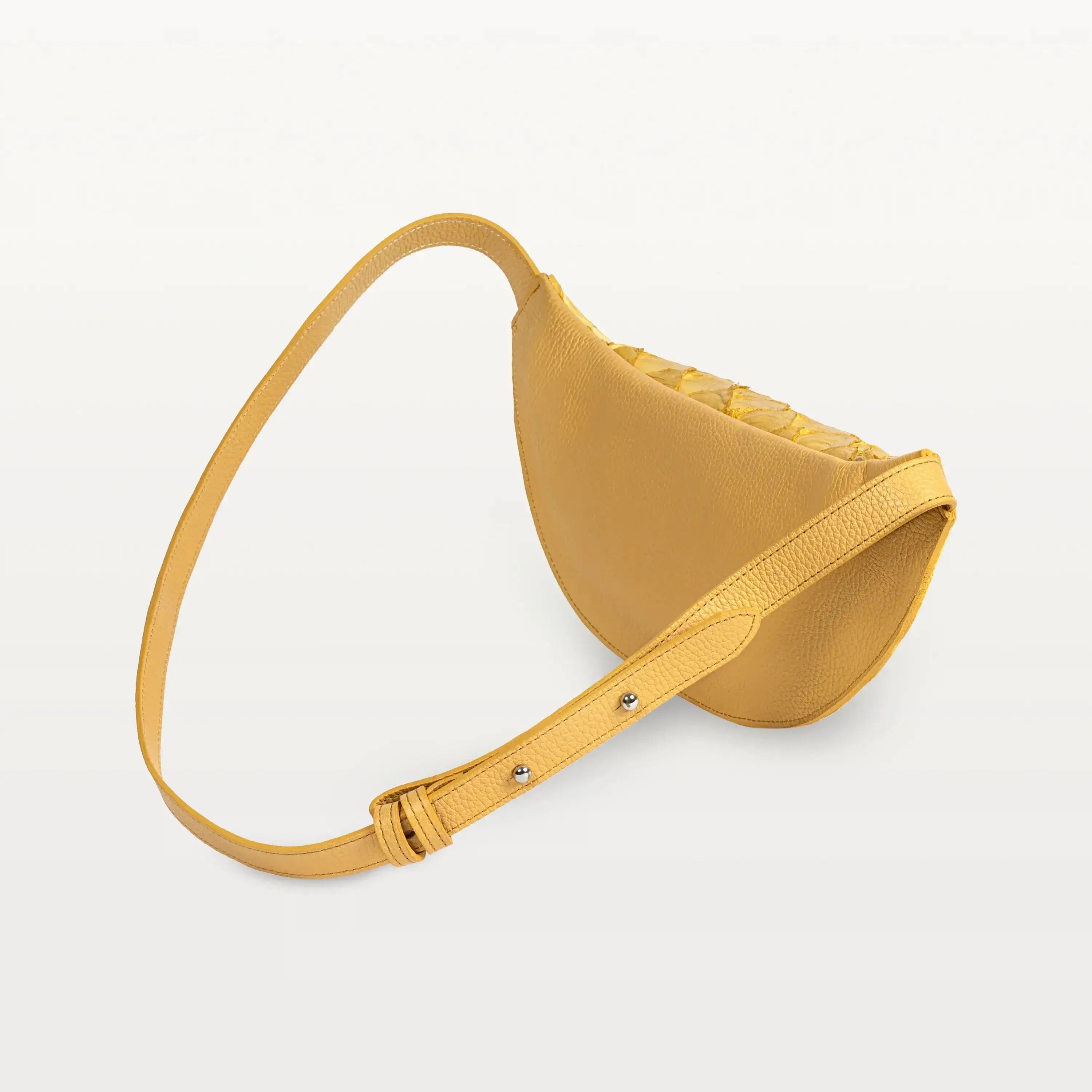 Back of the honey yellow pirarucu Mac Pack showing the bovine leather backside of the body and adjustable leather strap. 