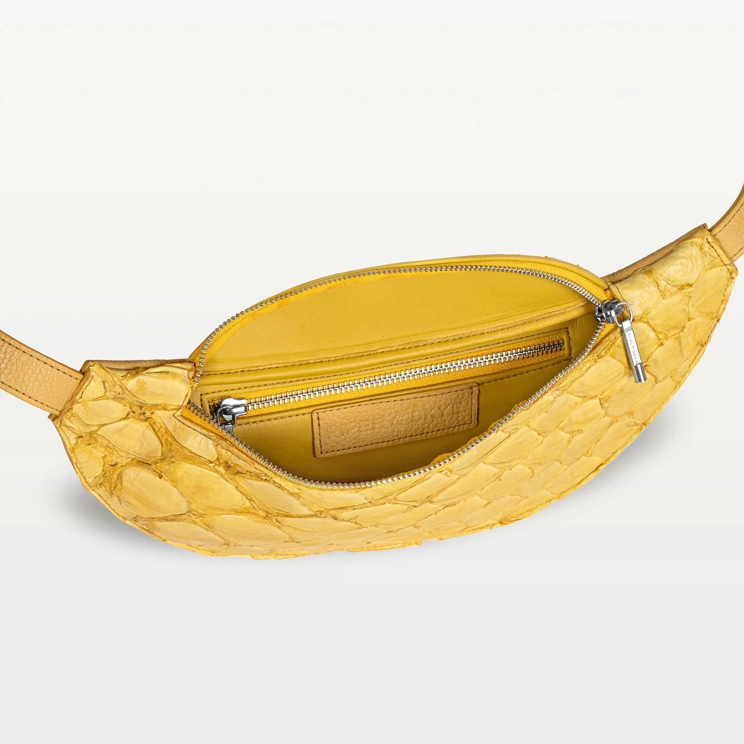 Mac Pack belt bag in honey yellow pirarucu fish leather with the top zipper open revealing an inner zippered pocket