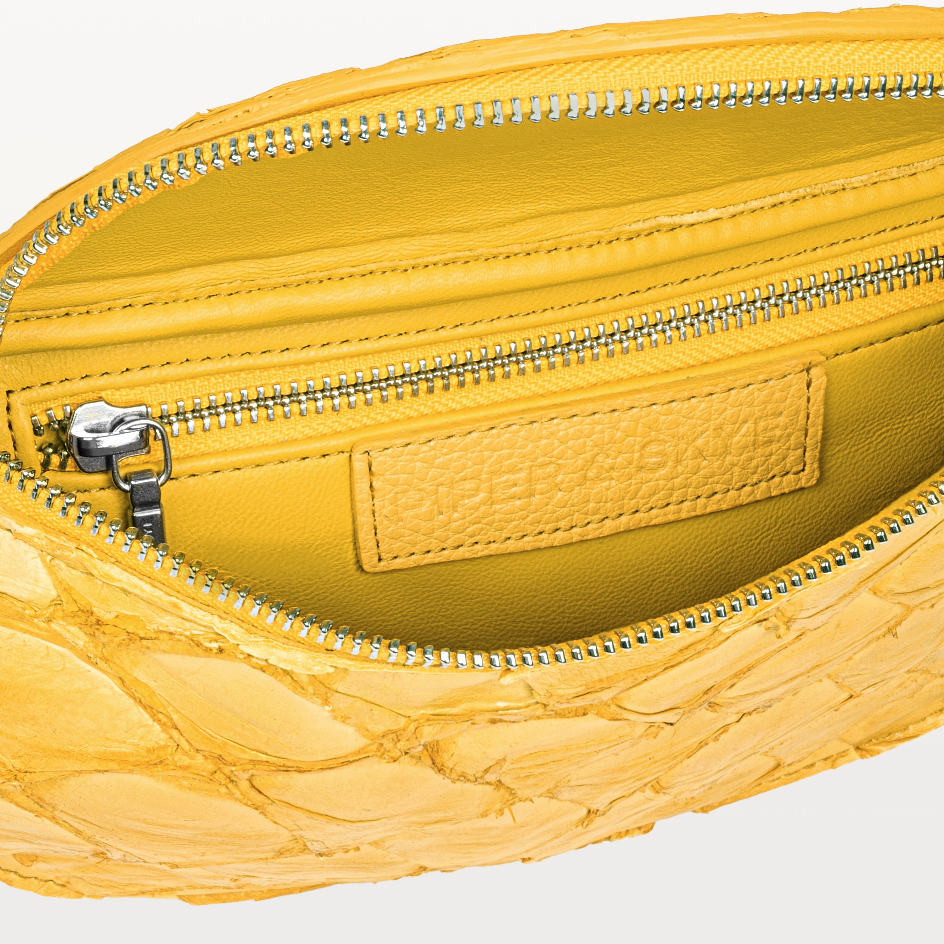 Yellow interior of the honey yellow pirarucu Mac Pack belt bag showing the inner zippered pocket. 
