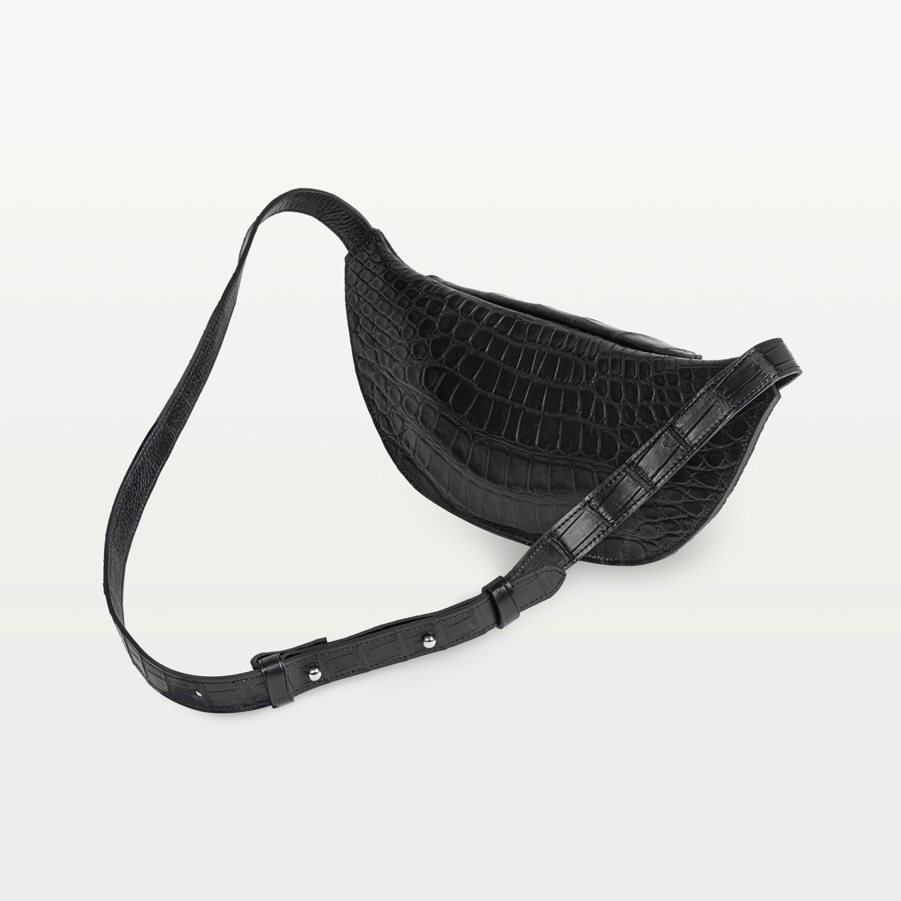 Back of the glossy black alligator Mac Pack showing the backside of the body and adjustable leather strap. 