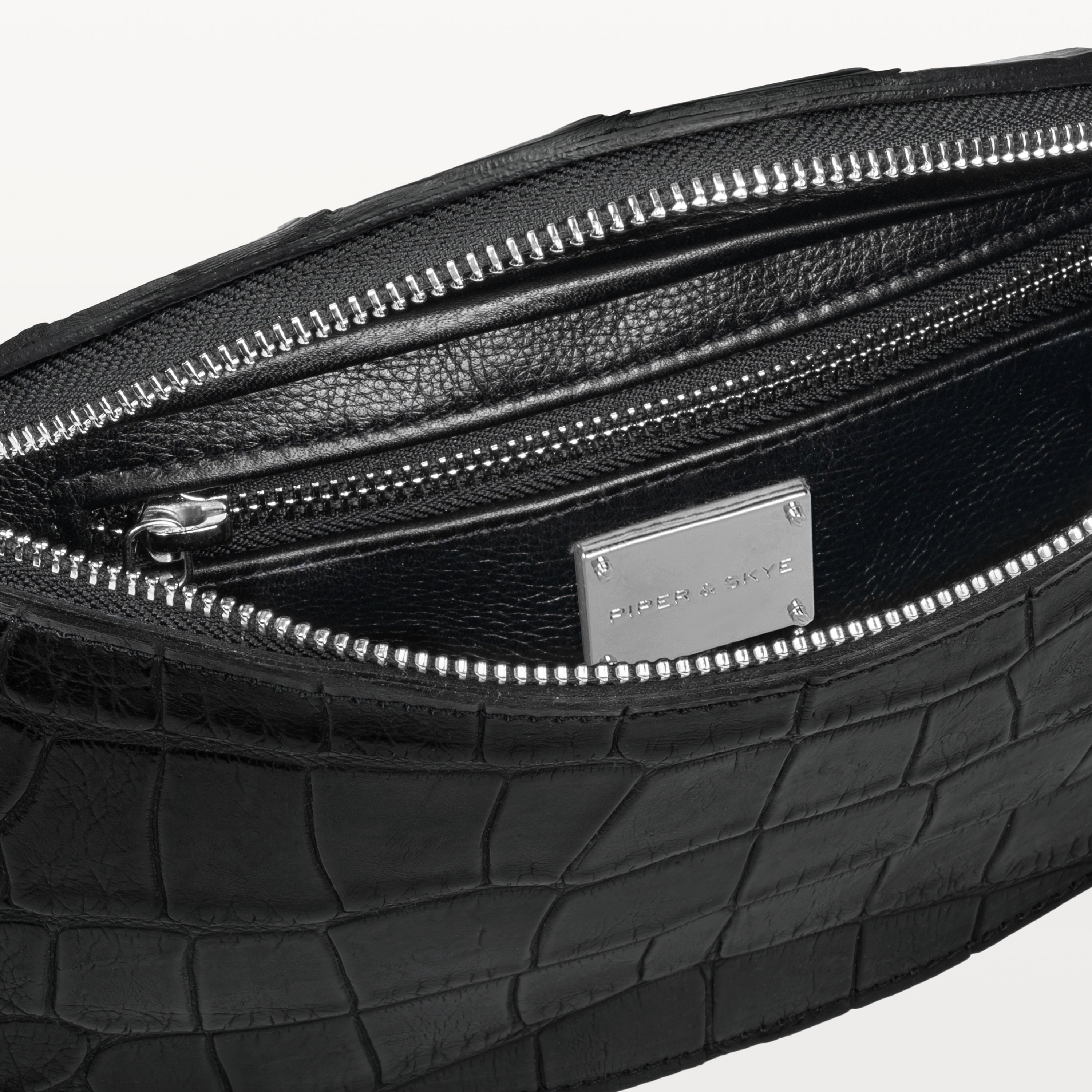 Black interior of the black alligator Mac Pack belt bag showing the inner zippered pocket. 