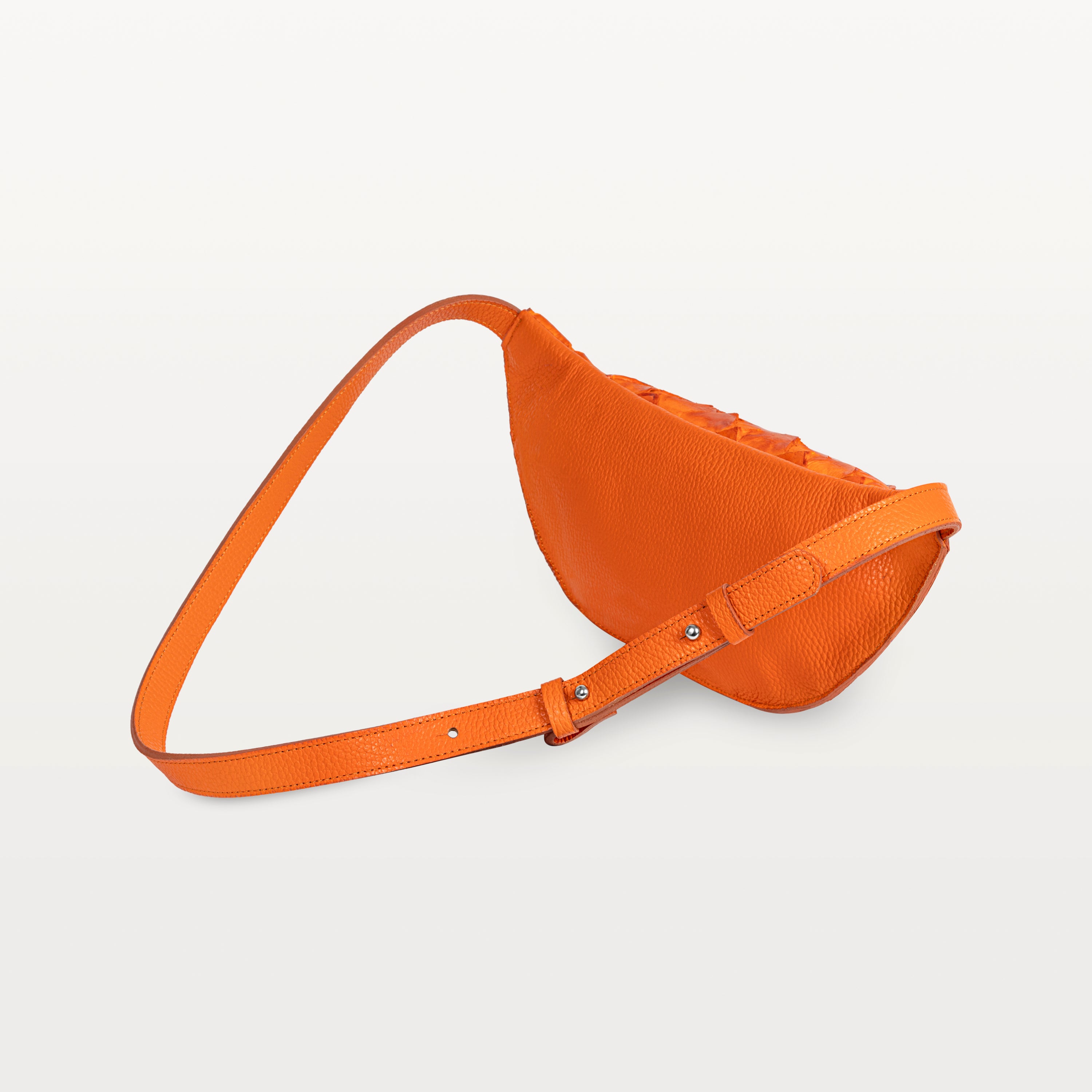 Back of the orange pirarucu Mac Pack showing the bovine leather backside of the body and adjustable leather strap. 