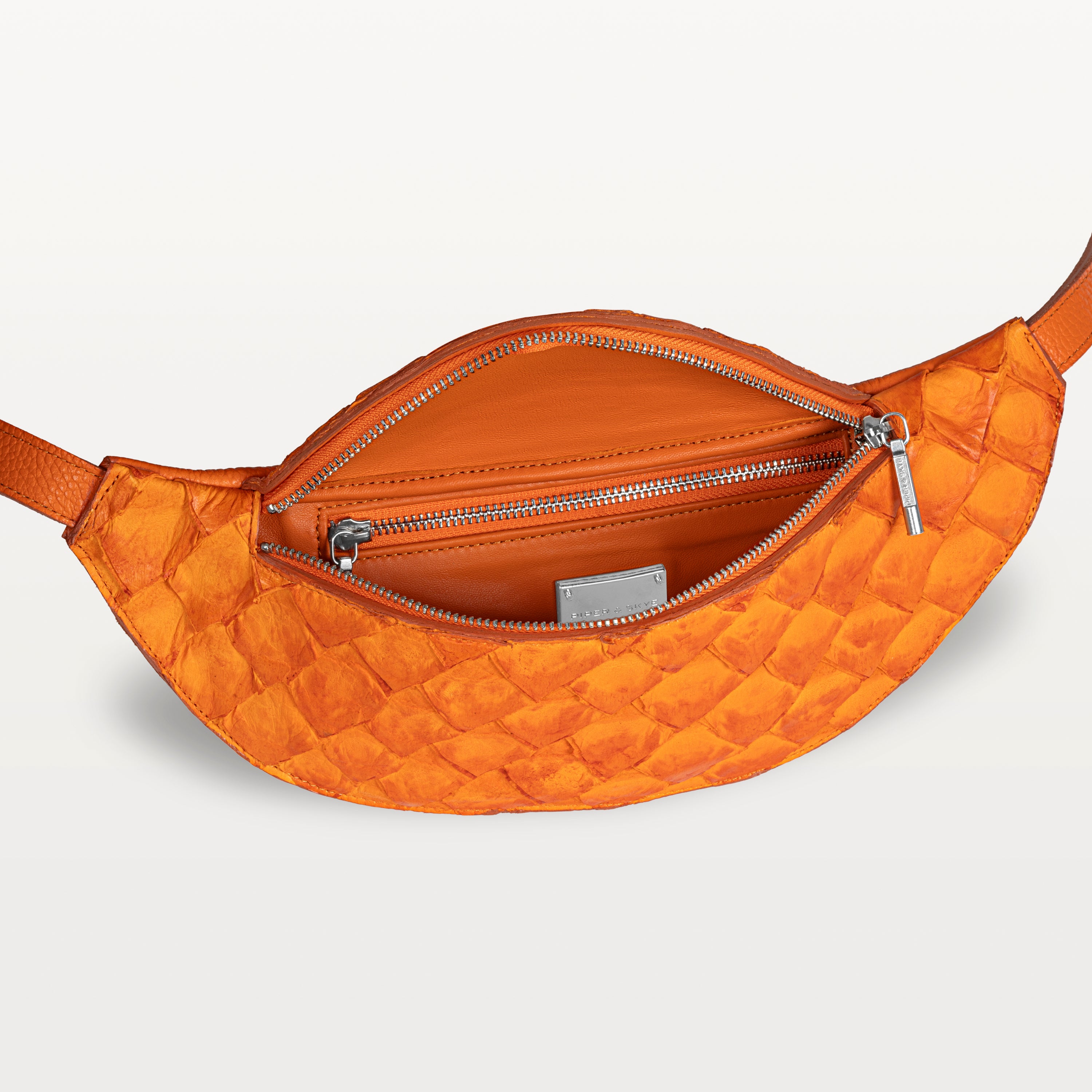 Mac Pack belt bag in orange pirarucu fish leather with the top zipper open revealing an inner zippered pocket