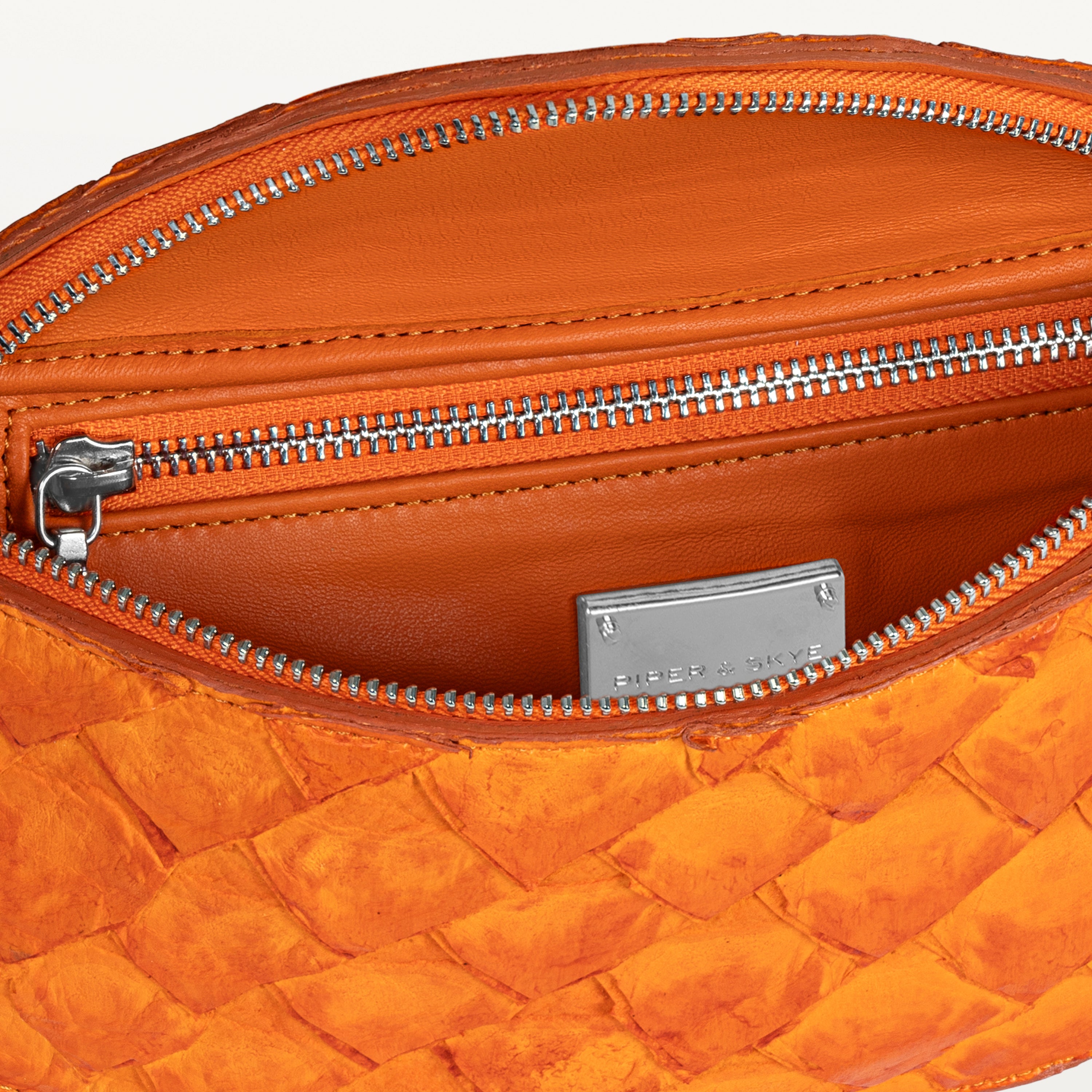 Orange interior of the orange pirarucu Mac Pack belt bag showing the inner zippered pocket. 