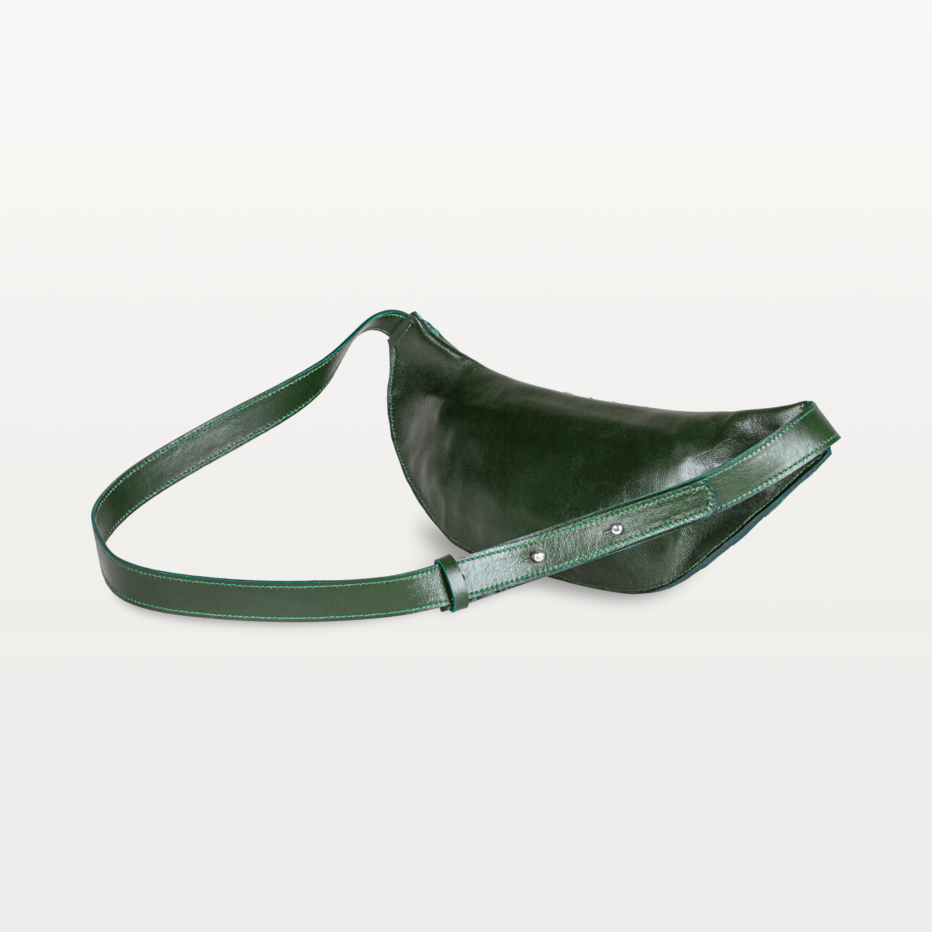 Back of the verdant green pirarucu Mac Pack showing the bovine leather backside of the body and adjustable leather strap. 