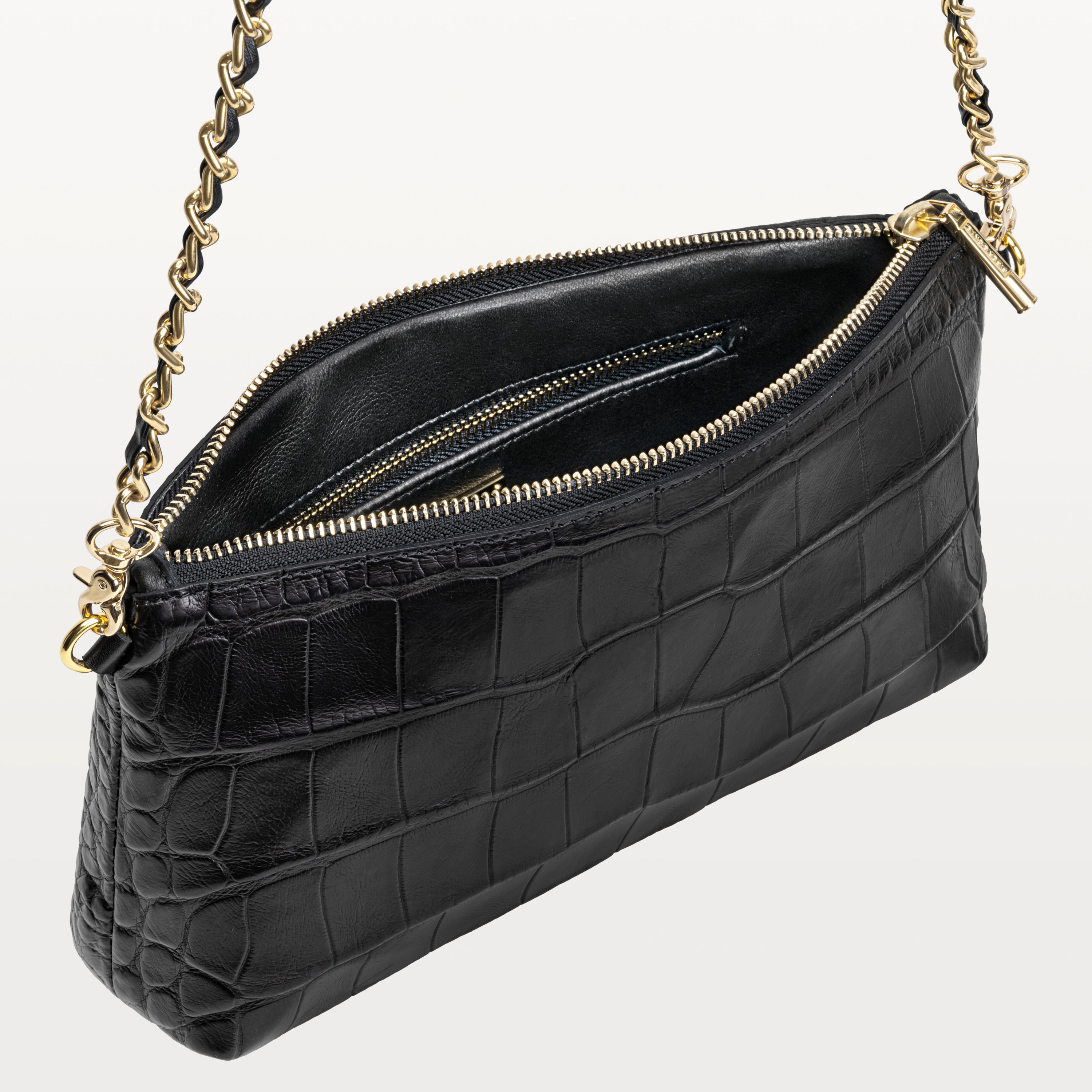 Interior view of the Nolita crossbody bag made from glossy black alligator along with its zippered inner pocket. 