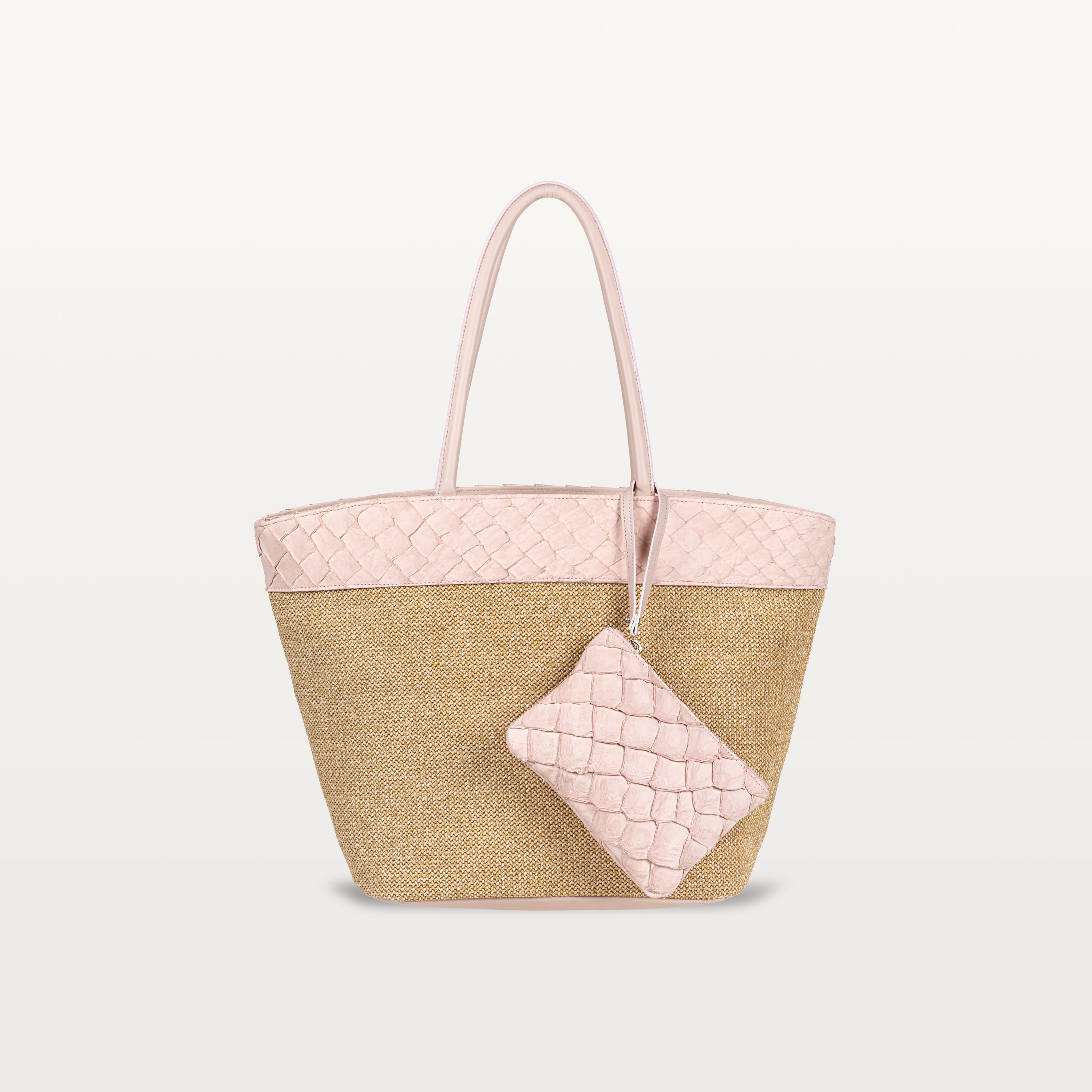 The Rio Beach Bag with a camel raffia body and pink pirarucu leather trim. A matching pink pirarucu leather wristlet hangs from the strap