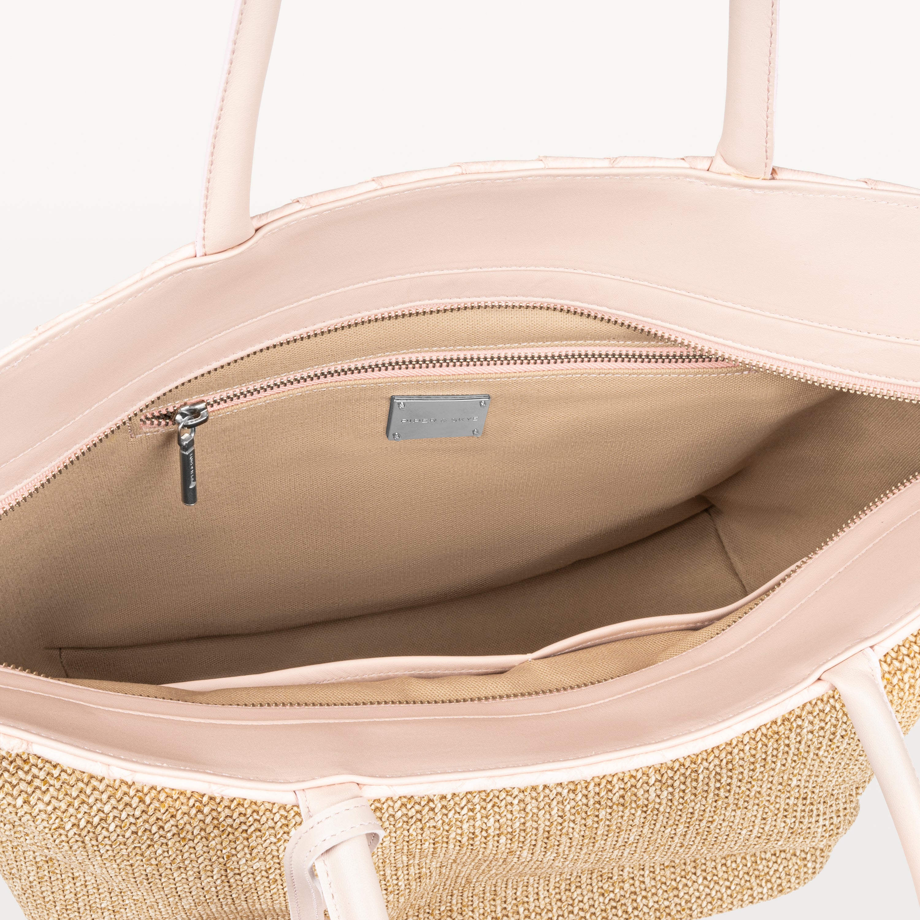The top zipper of the Rio Beach Bag in pink pirarucu leather is open showing the beige interior lining and inner zipper pocket. 