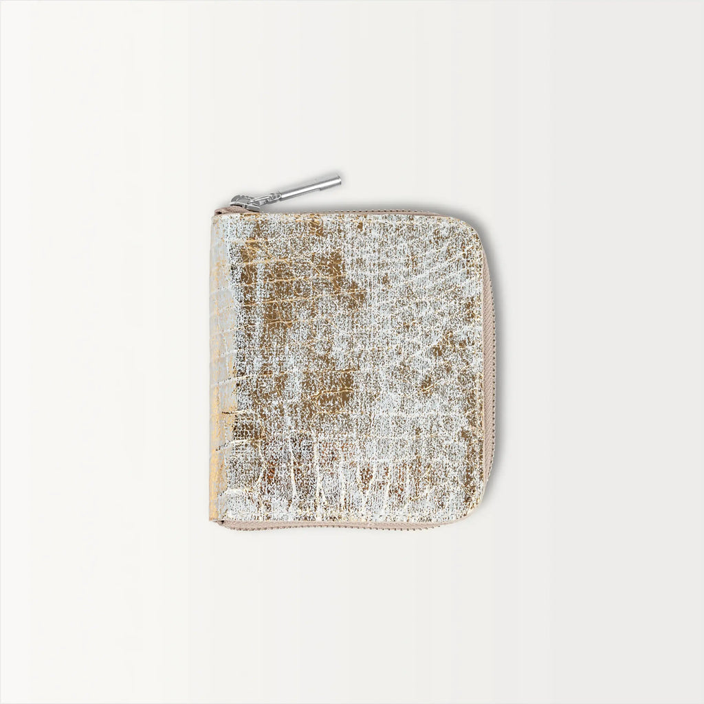 The Shore Zip Wallet in metallic gold alligator leather, shown closed with a silver zipper pull