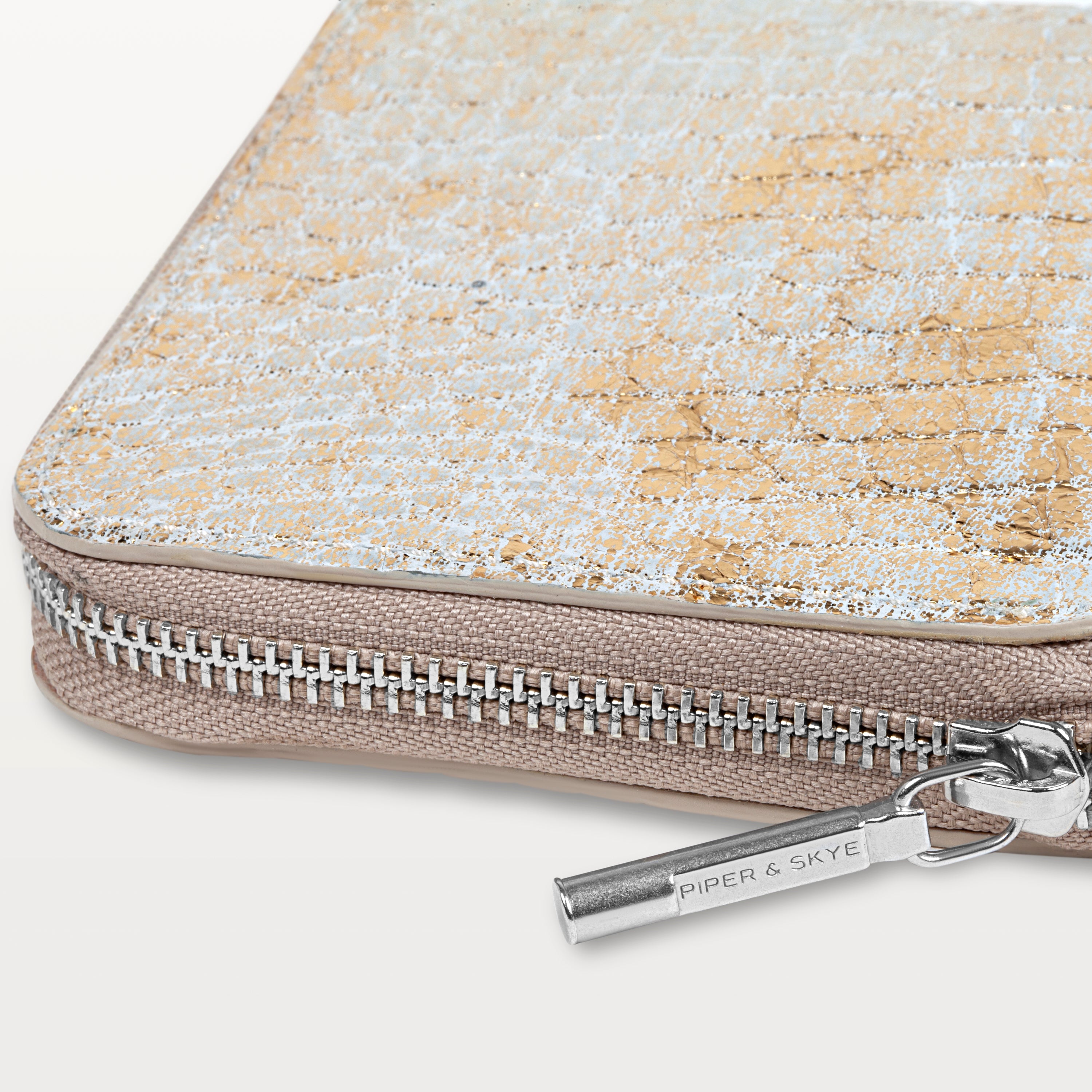 Detail shot of the Shore Zip Wallet in metallic gold alligator leather showing the zip around closure and sliver zipper pull. 