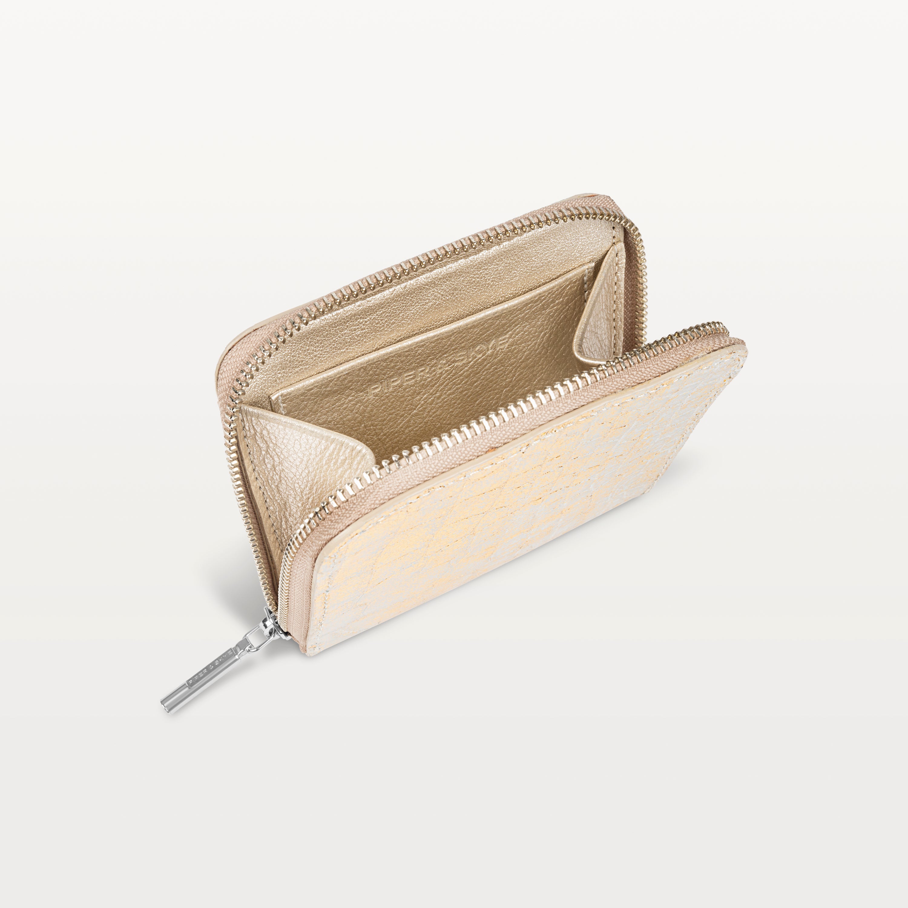 Zip around closure of the Shore Zip Wallet in metallic gold alligator leather opened to show the gold inner slip pocket.