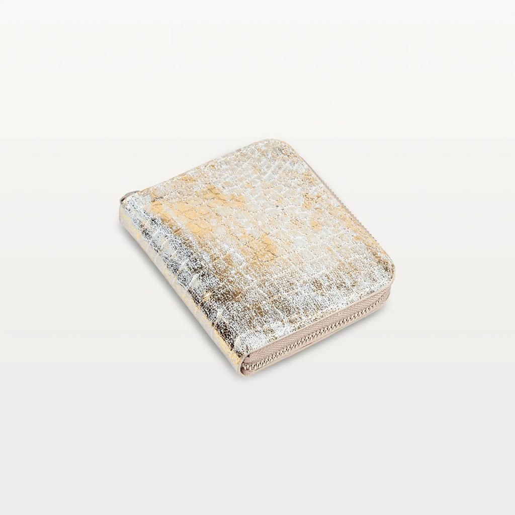 Angled view of the Shore Zip Wallet in metallic gold alligator leather, showing its zip-around closure and square shape